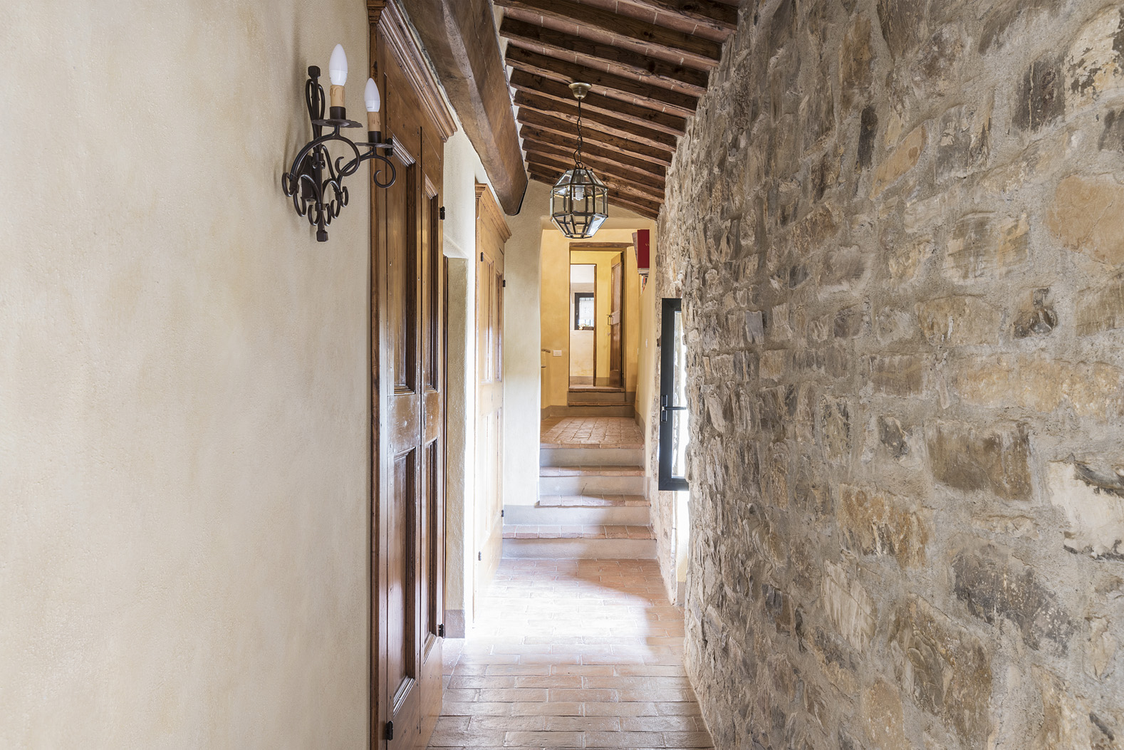 Charming Chianti villa bedroom with canopy bed, floral decor, and scenic window view