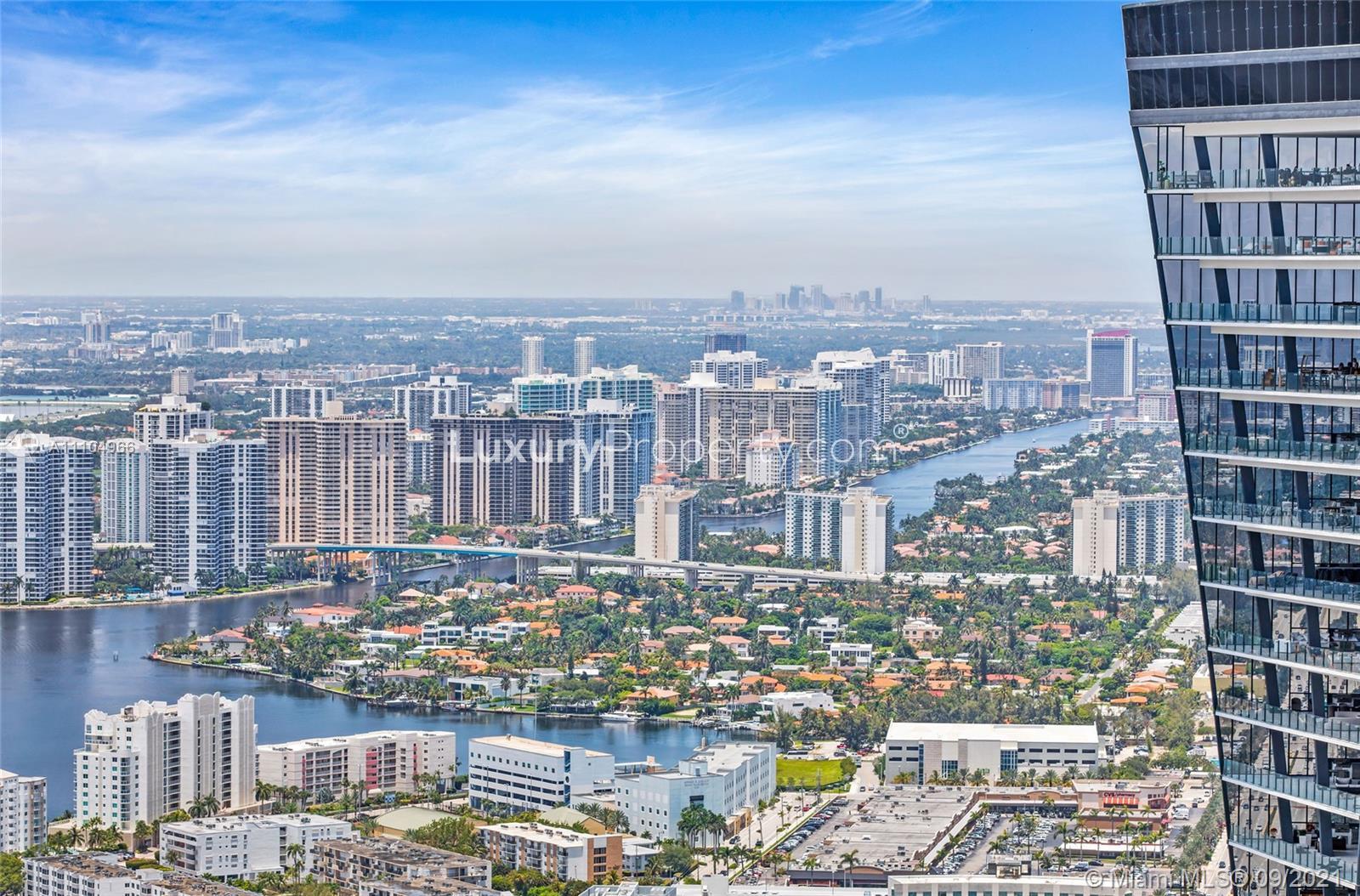Miami oceanfront penthouse view, high-rise buildings, skyline, and waterway at Collins Ave