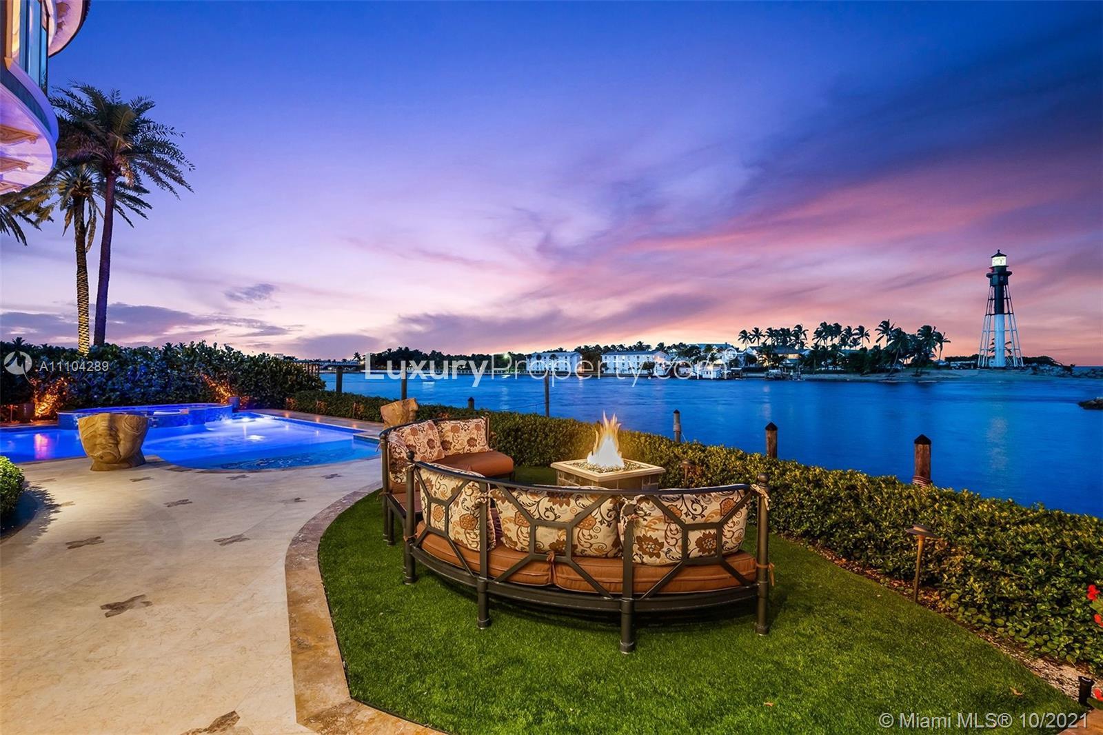 Luxurious Miami villa patio with ocean view, pool, and lighthouse at sunset
