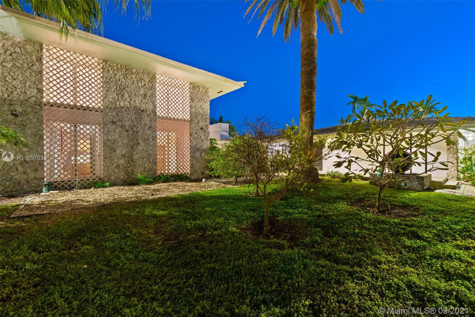 Exterior view of luxury Belle Meade Island residence with lush landscaping and modern architecture