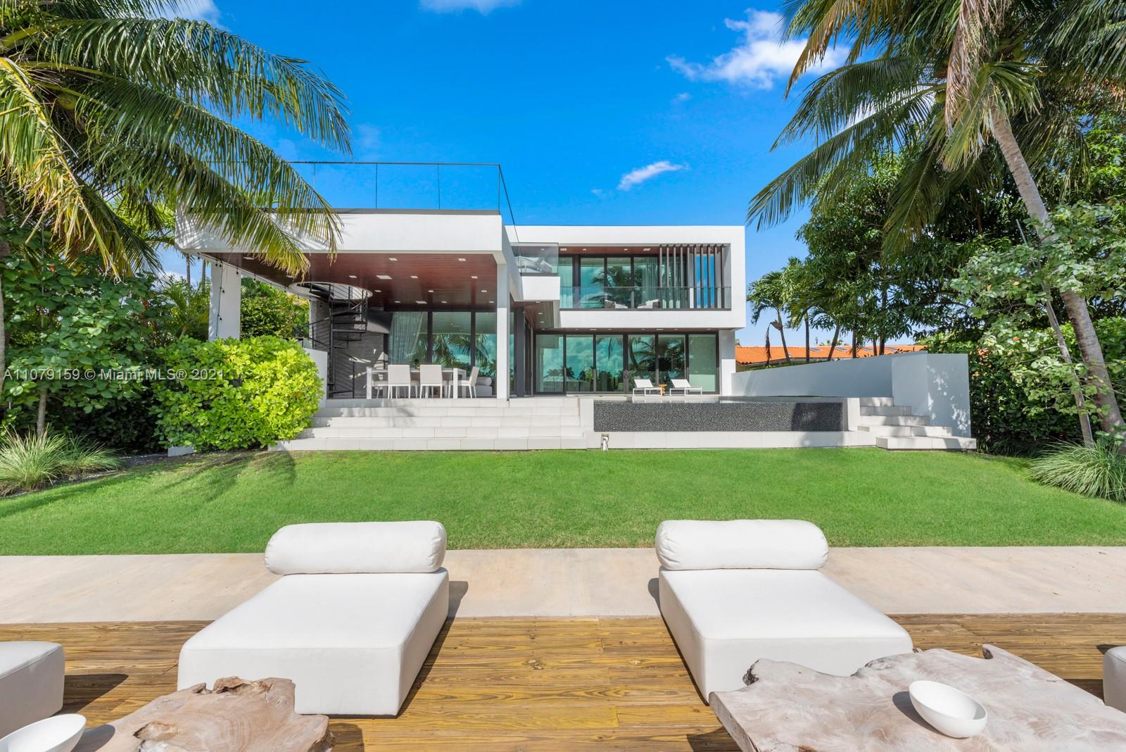 "Luxurious waterfront villa patio with seating area overlooking Biscaya Island, Miami, Florida.",Waterfront villa on Biscaya Island, Miami with modern design and lush greenery