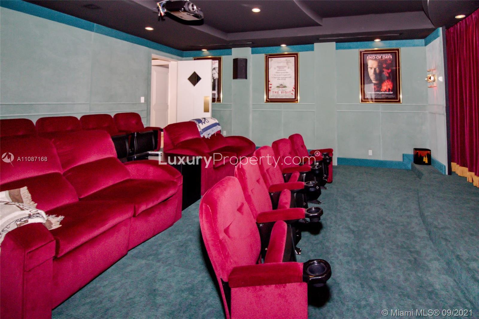 Home theater with plush red seating in Highland Beach villa, Florida