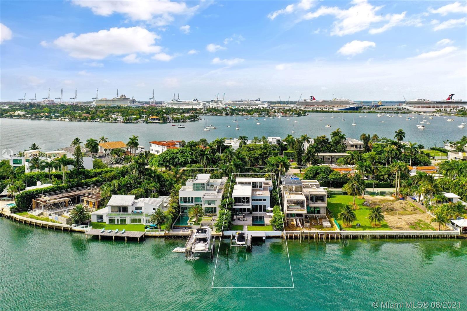 Aerial view of luxury villa with waterfront, dock, and lush greenery in Miami, Florida