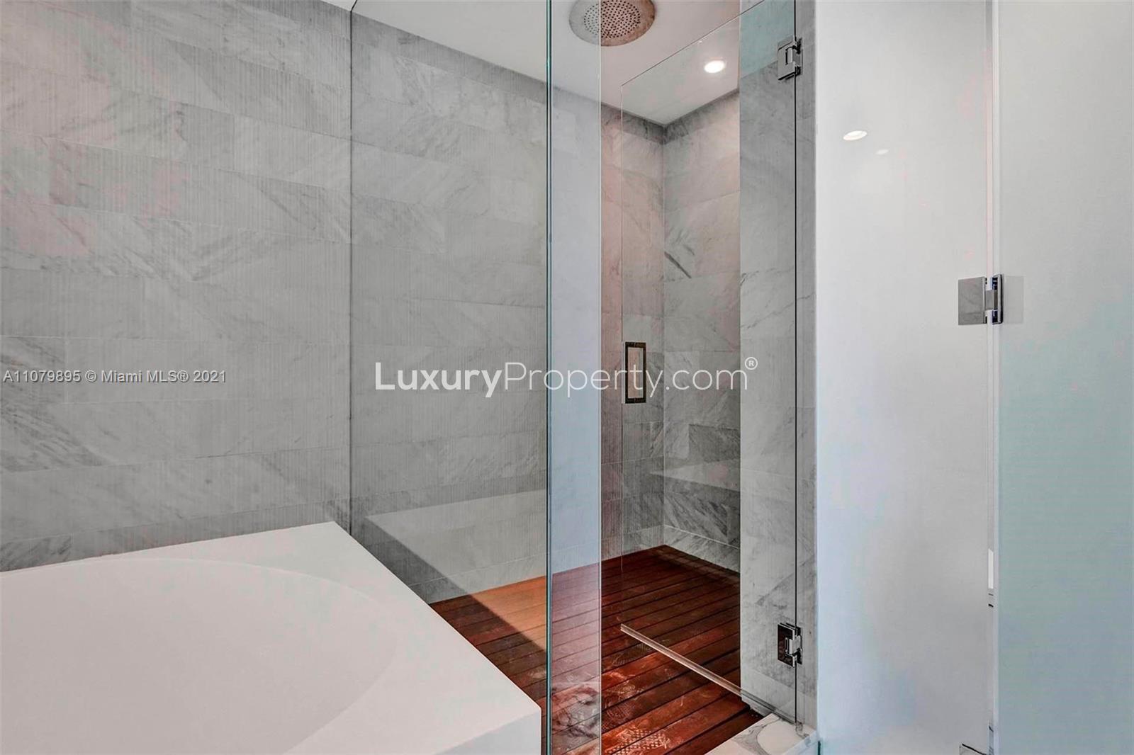 Luxurious marble bathroom with glass shower in Bal Harbour condo, Miami villa for sale