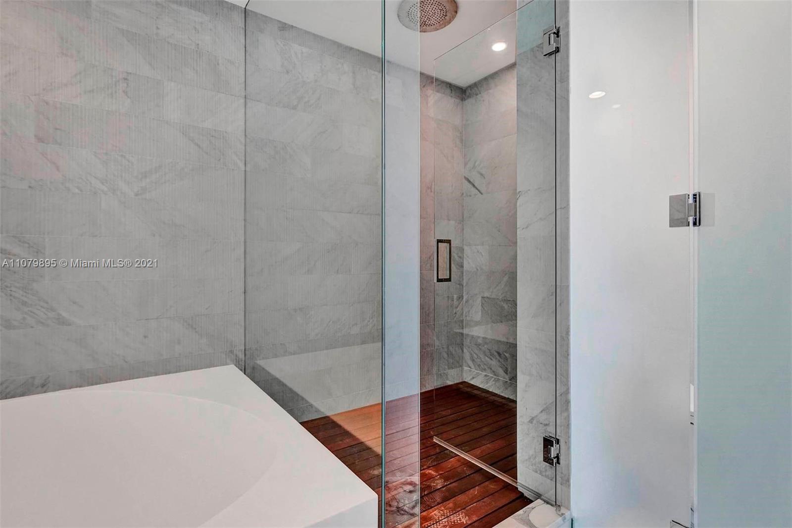 Luxurious marble bathroom with glass shower in Bal Harbour condo, Miami villa for sale