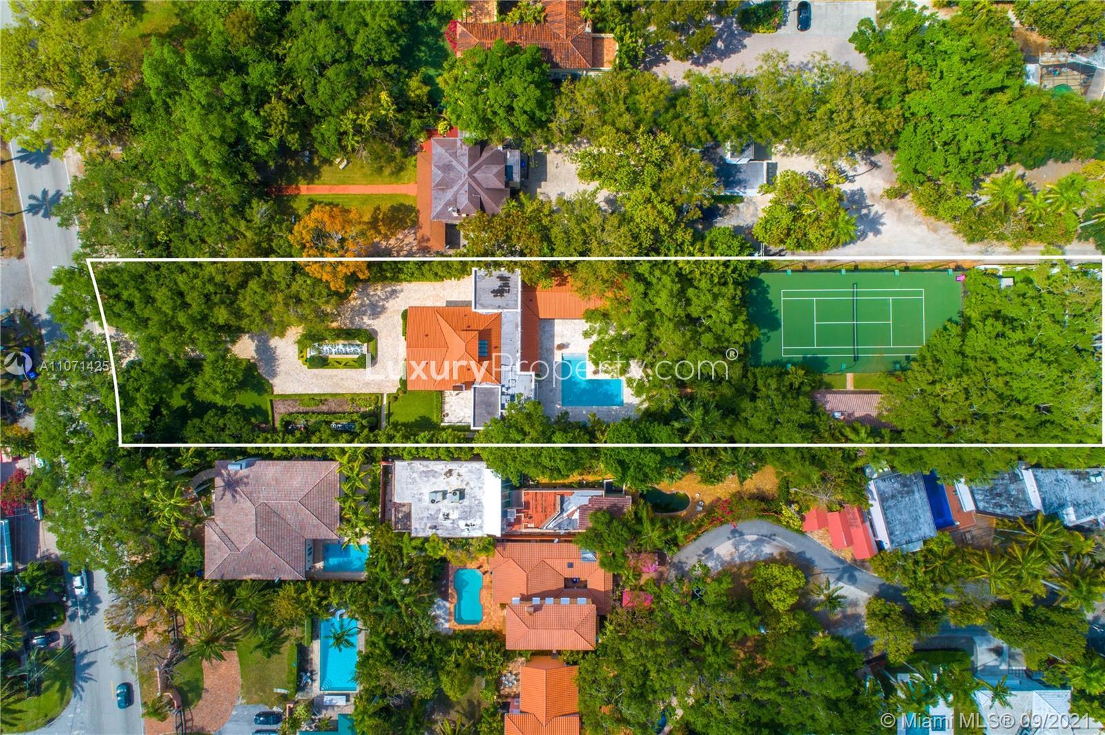 Aerial view of villa with tennis court in Miami, Florida, surrounded by lush greenery