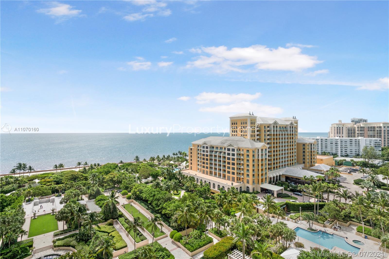 "Spacious terrace with ocean view in Key Biscayne penthouse, featuring elegant outdoor furniture.",Modern four-bed penthouse view, Key Biscayne, Florida, overlooking ocean and lush greenery