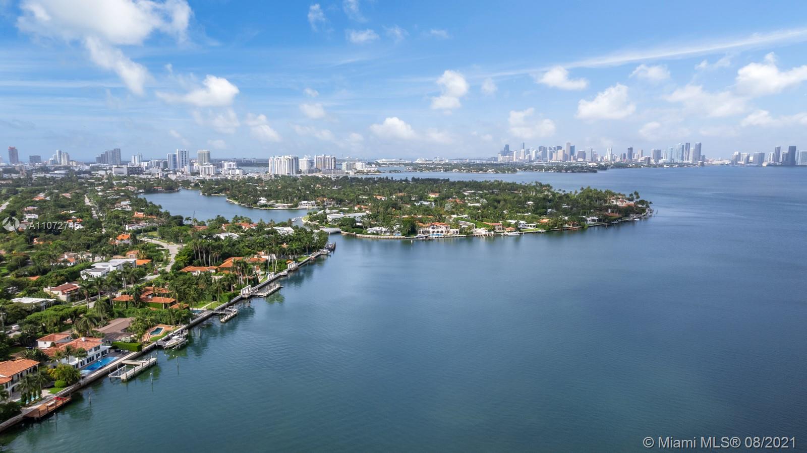 Aerial view of Miami's luxury villas near waterfront, showcasing lush greenery and scenic skyline