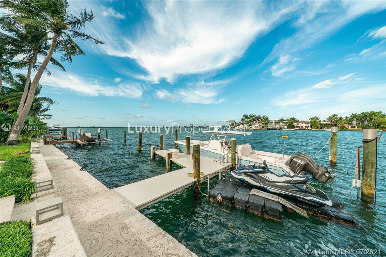 Luxurious Miami villa garden with illuminated pathway and lush greenery at night