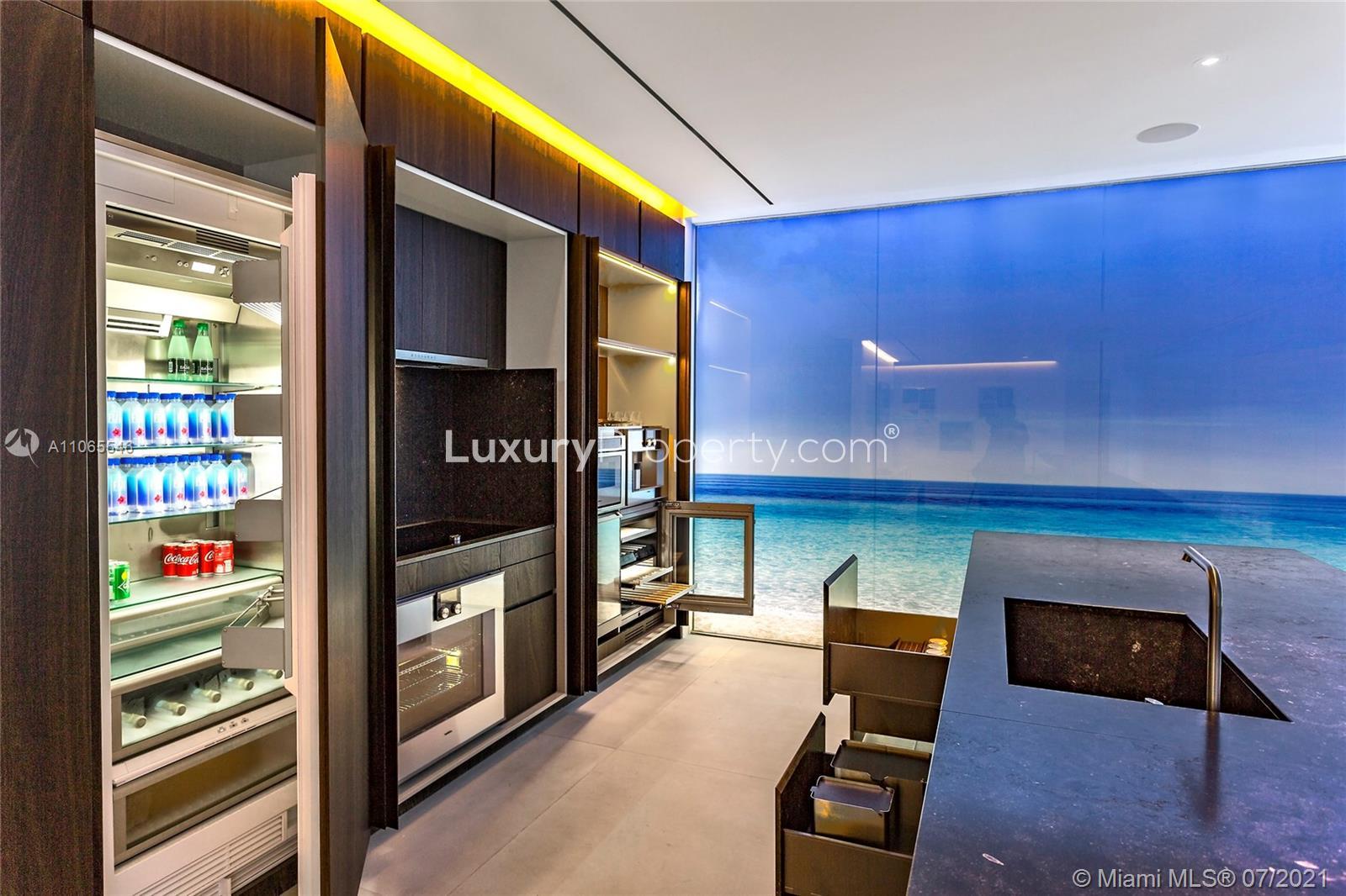 Modern kitchen in six-bedroom Hallandale Beach penthouse with ocean-themed decor and sleek appliances