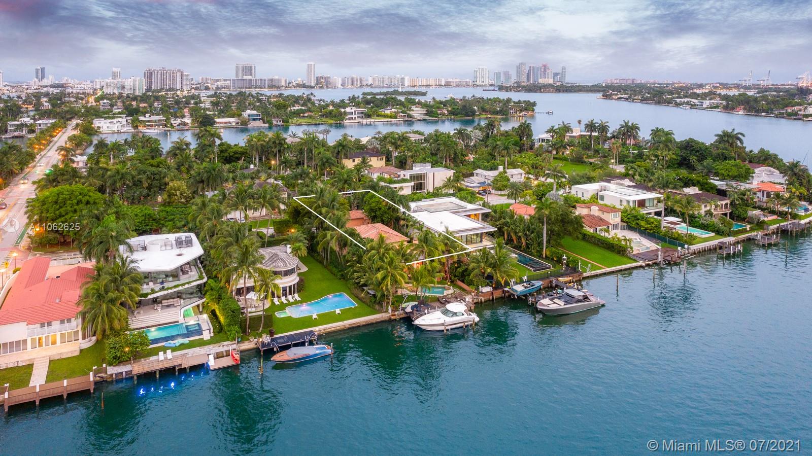 Aerial view of luxury villa community in Miami with waterfront and lush greenery