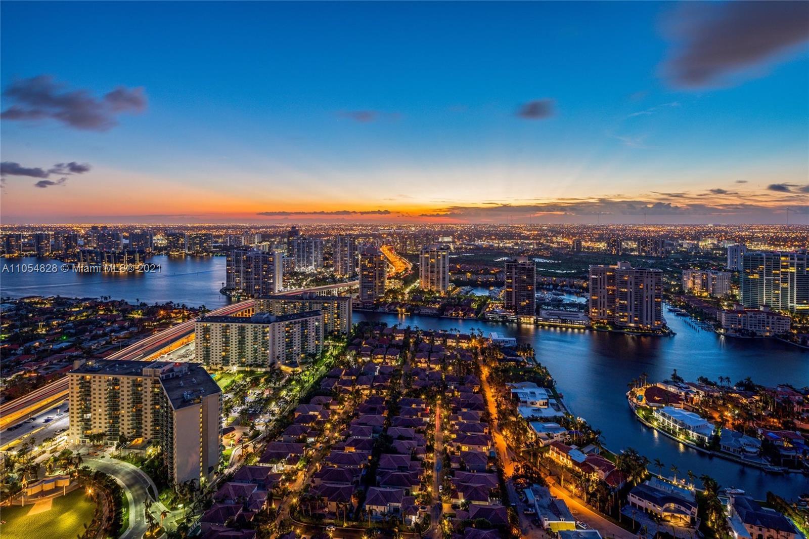 Aerial view of Miami skyline near ocean, highlighting luxury villa location at sunset