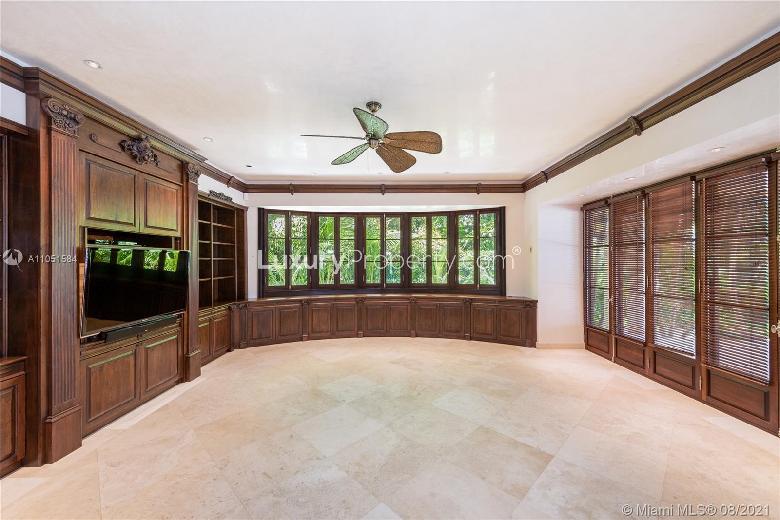Luxurious living room in rustic Miami Beach villa with wooden cabinetry and large windows
