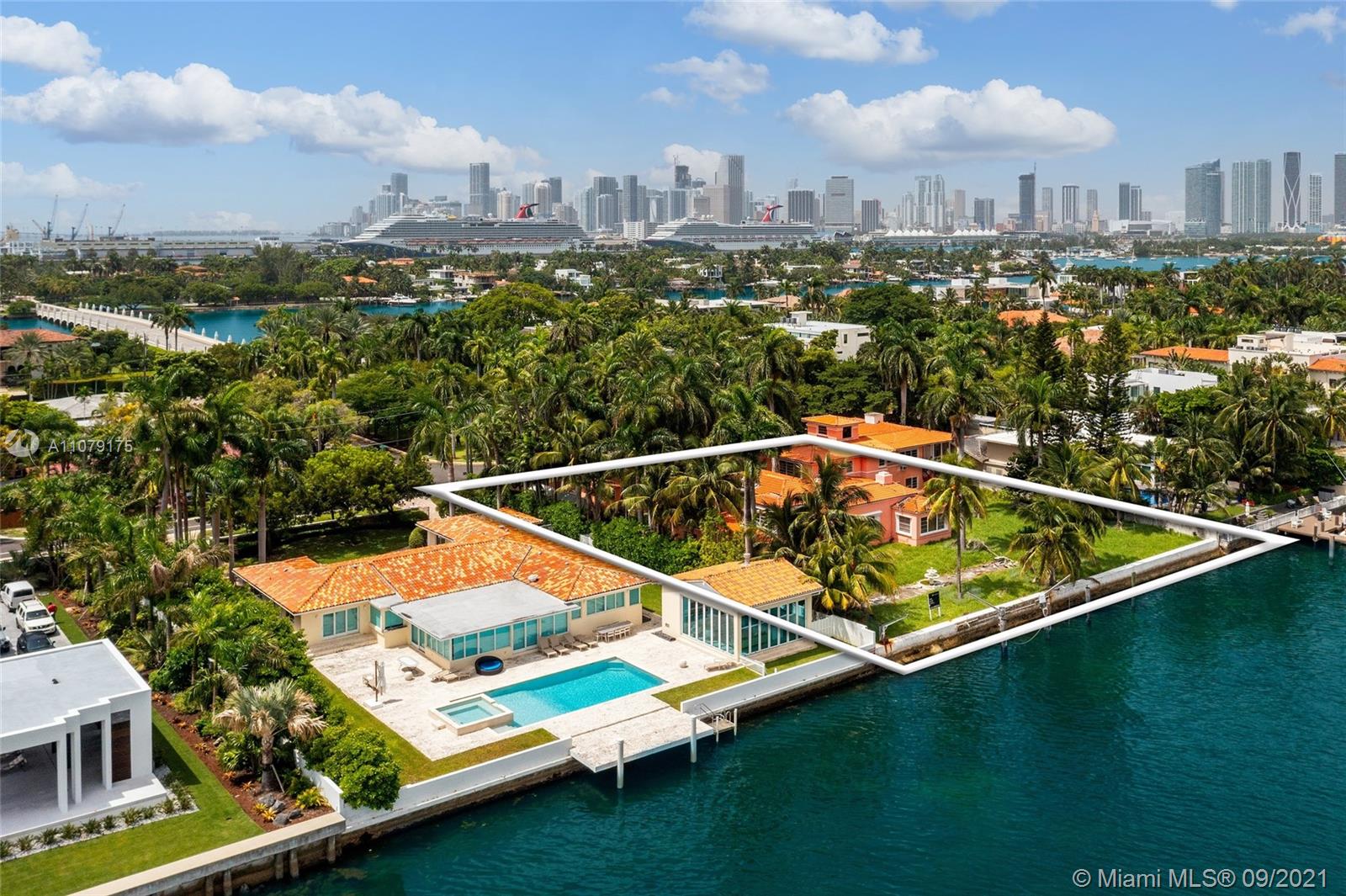 Oceanfront single family residence in Miami Beach with lush greenery and city skyline view