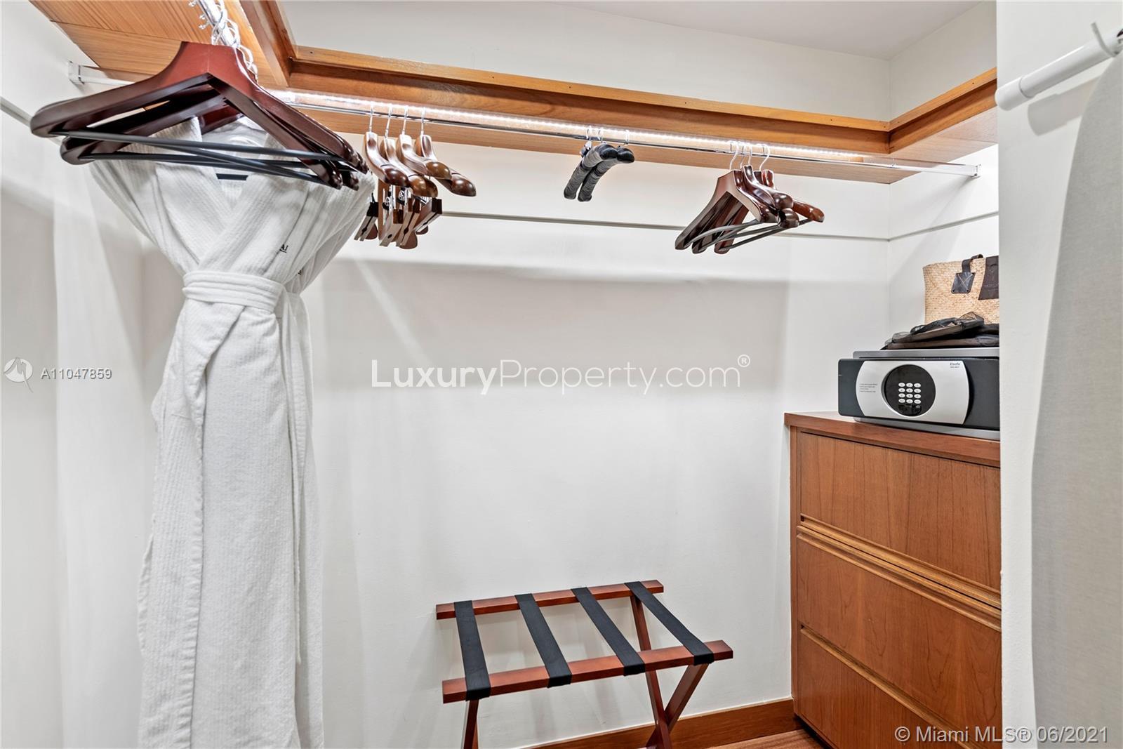 Contemporary Miami villa bedroom with scenic golf course view, hardwood floors, and large windows