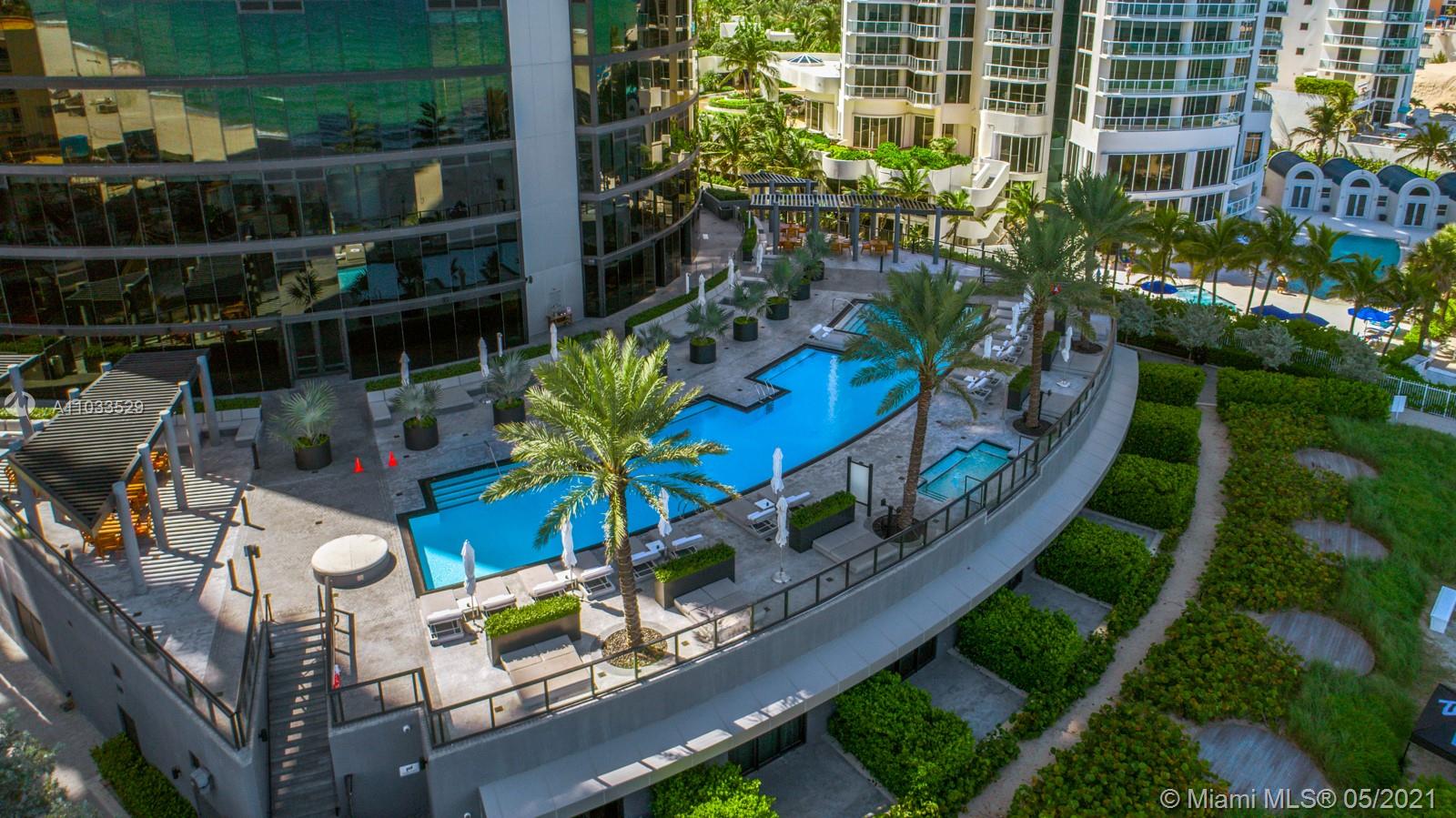 Luxury Miami villa pool with ocean view, palm trees, and sunlit sky at Collins Ave