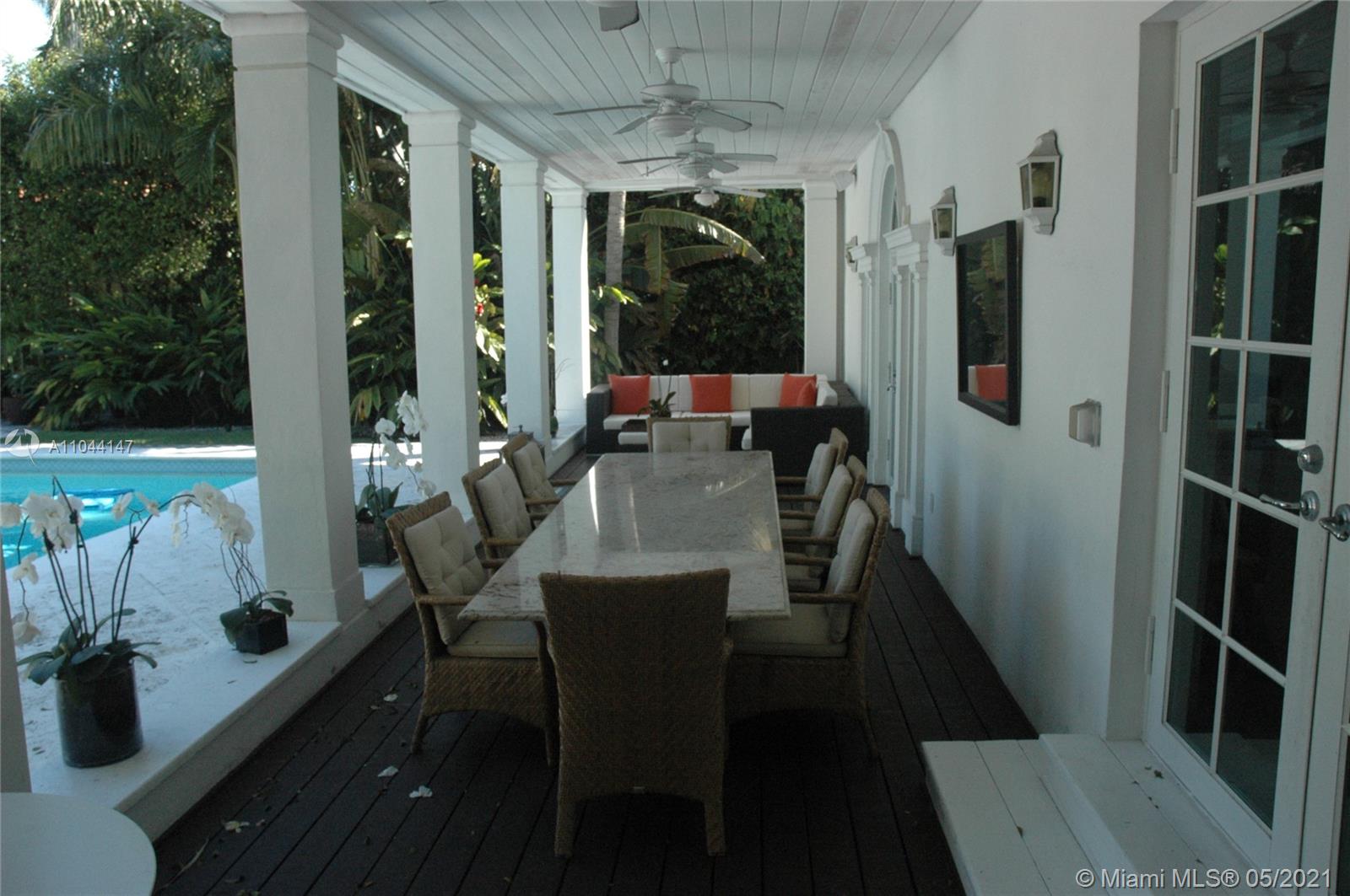 Waterfront villa pool with palm trees and boats, Miami Beach, for sale