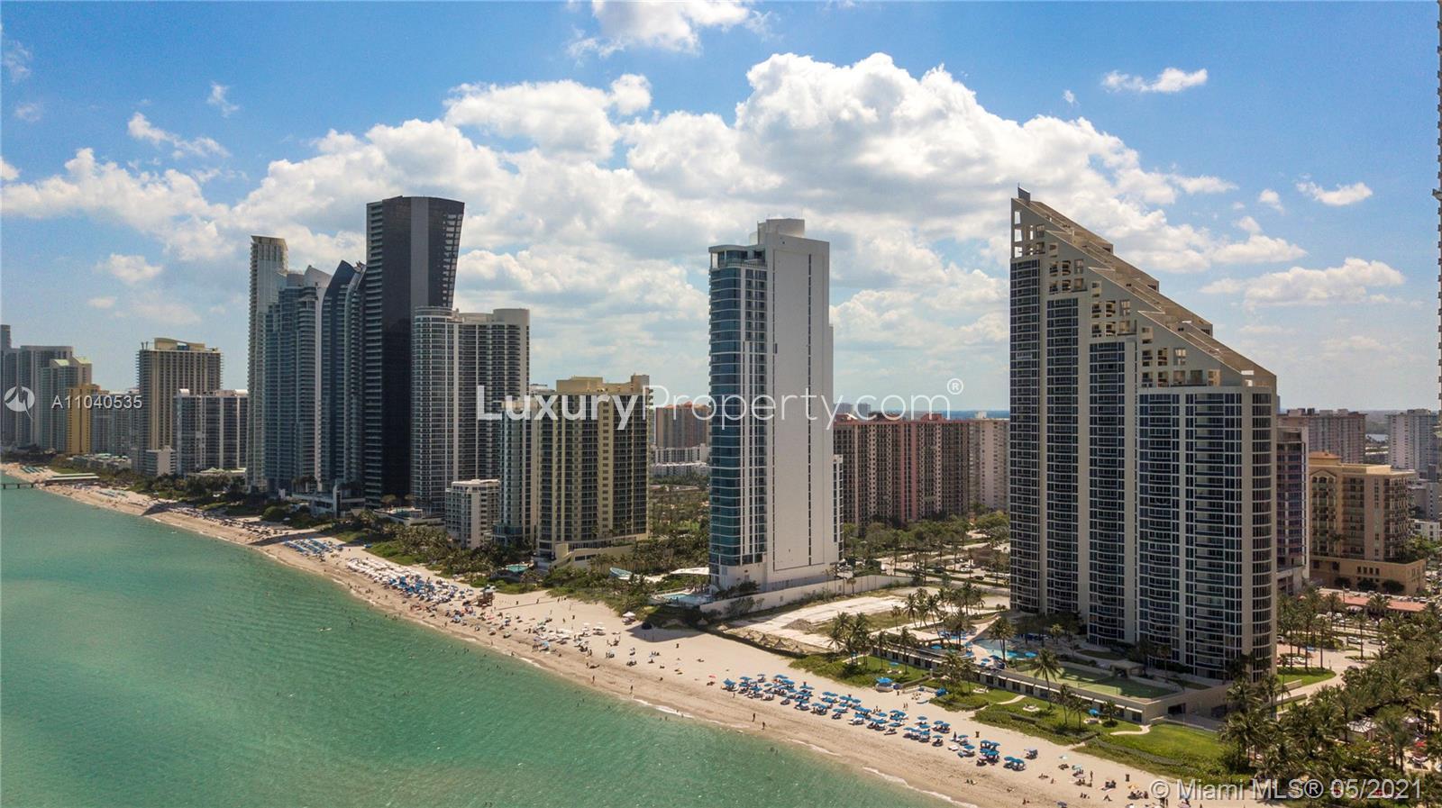 Luxury Miami penthouse exterior at 17475 Collins Ave, featuring modern architecture and palm trees