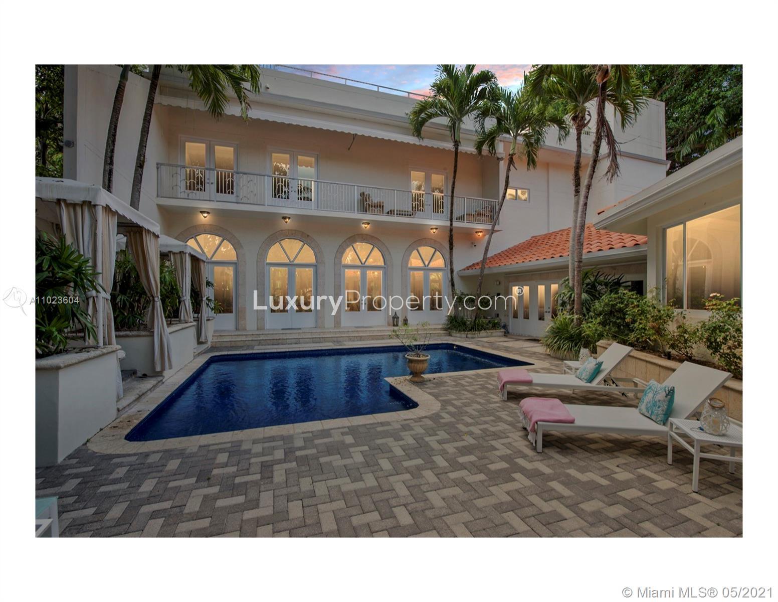 Elegant dining room in Miami Beach villa, featuring chandeliers and artwork, Bayshore Drive