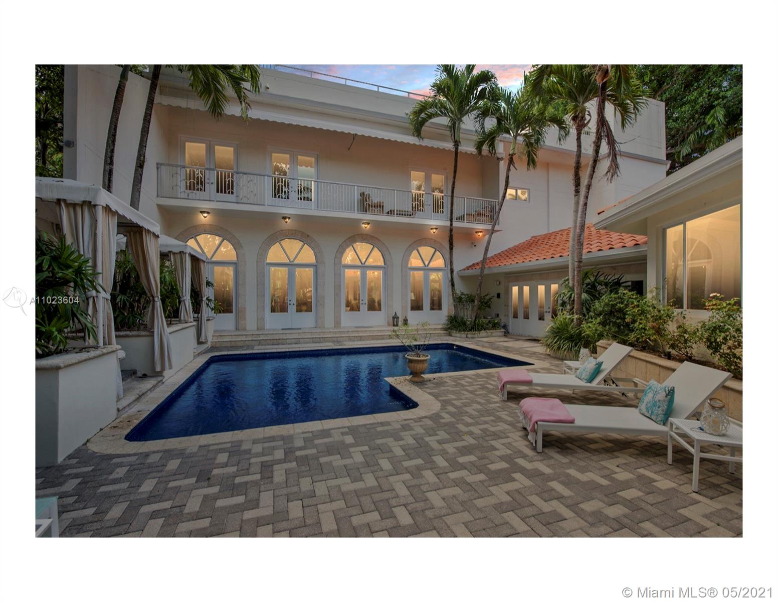 Elegant dining room in Miami Beach villa, featuring chandeliers and artwork, Bayshore Drive