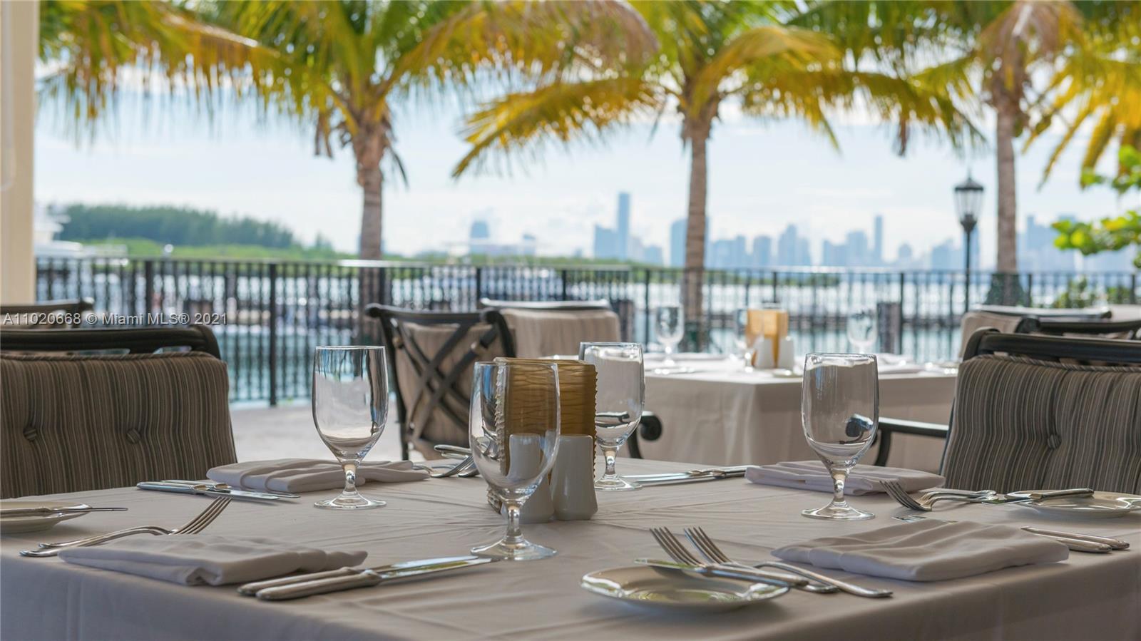 "Elegant dining setup with ocean view at Miami villa, Fisher Island Dr, Florida.",Luxurious dining area in ocean view mansion, Fisher Island, Miami villa for sale
