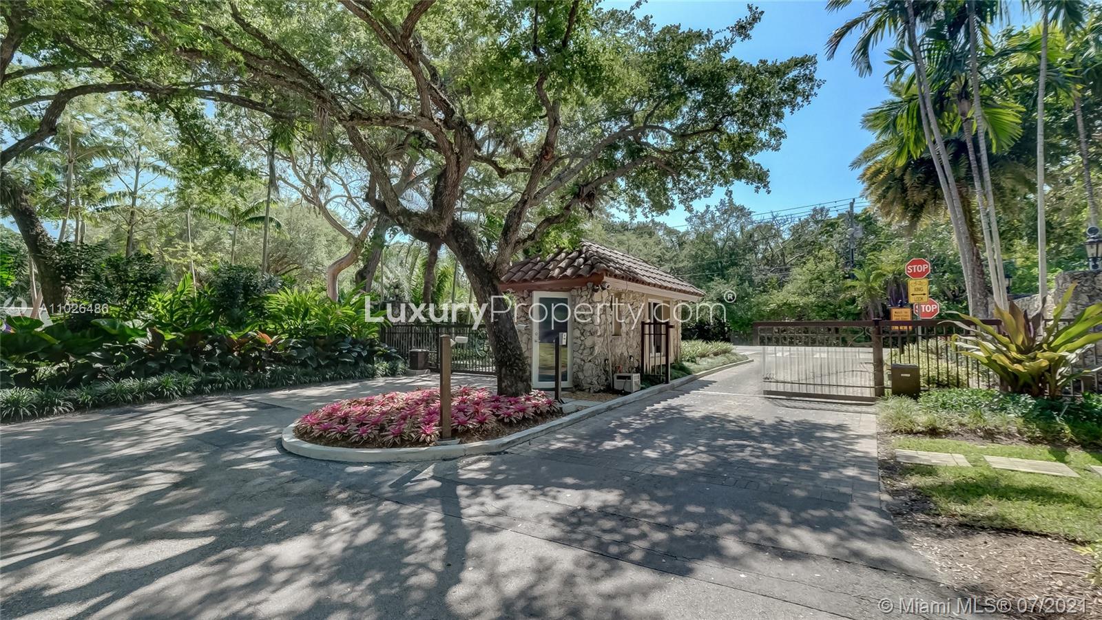 Gated entrance of luxury seven-bed villa in Coral Gables, Miami, surrounded by lush greenery