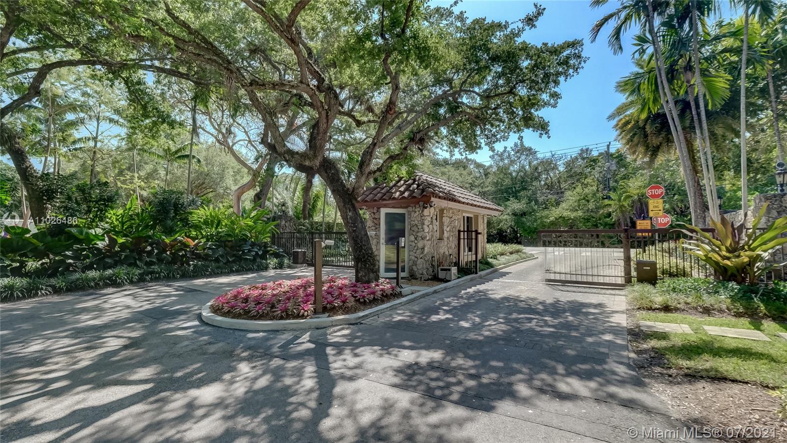 Gated entrance of luxury seven-bed villa in Coral Gables, Miami, surrounded by lush greenery