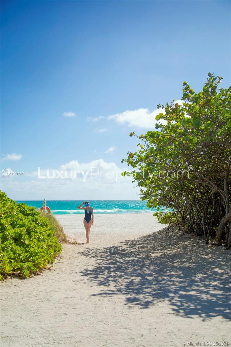 Luxury Miami Beach villa balcony with ocean and city views, modern seating, and pool area
