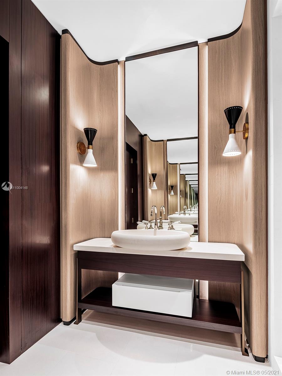 "Modern villa entrance with green marble wall, Miami Beach, LP09917, seven-bed luxury home.",Modern bathroom with elegant sink in Miami Beach seven-bed villa for sale