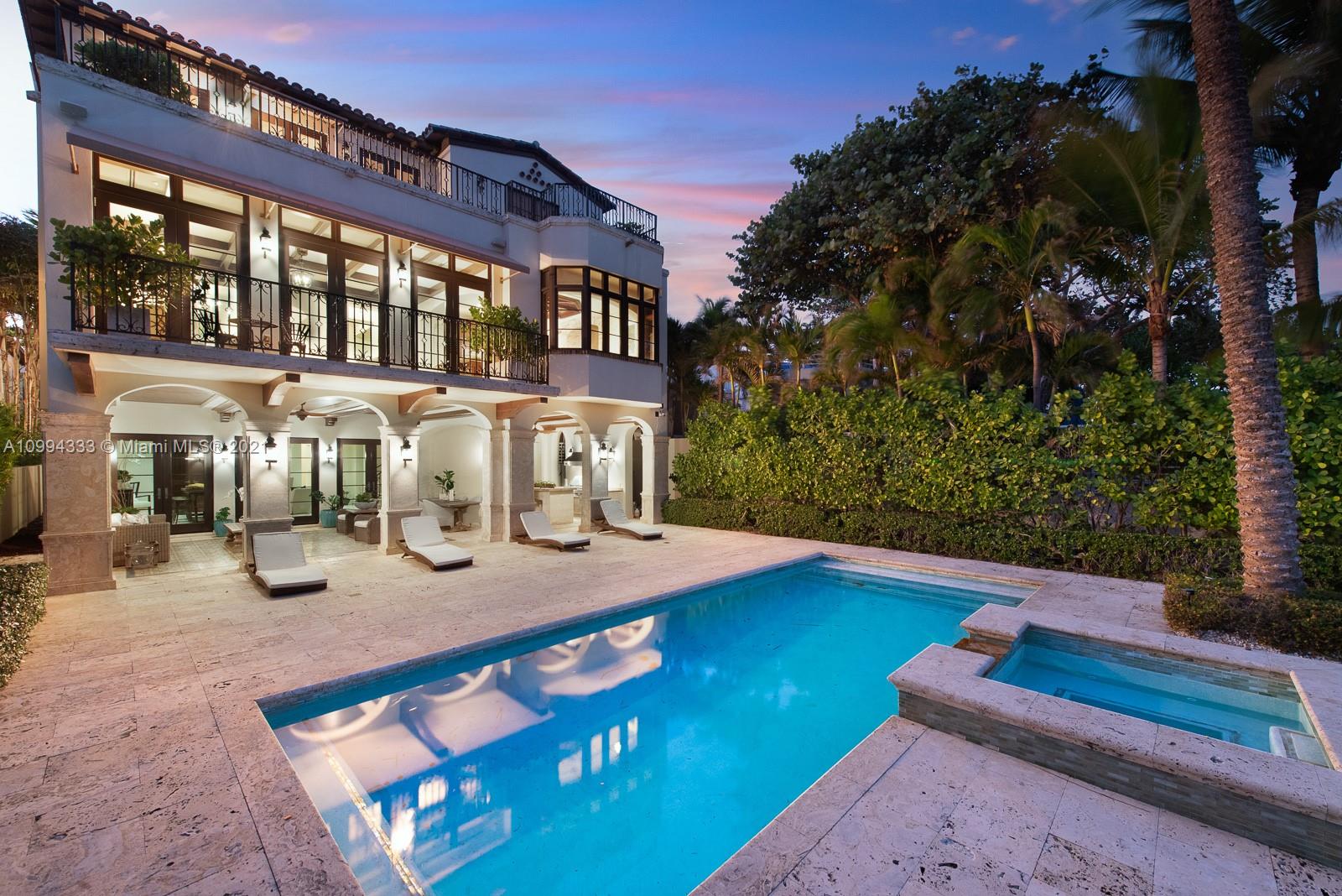 Spanish Mediterranean villa with pool and palm trees at sunset, Miami, Florida