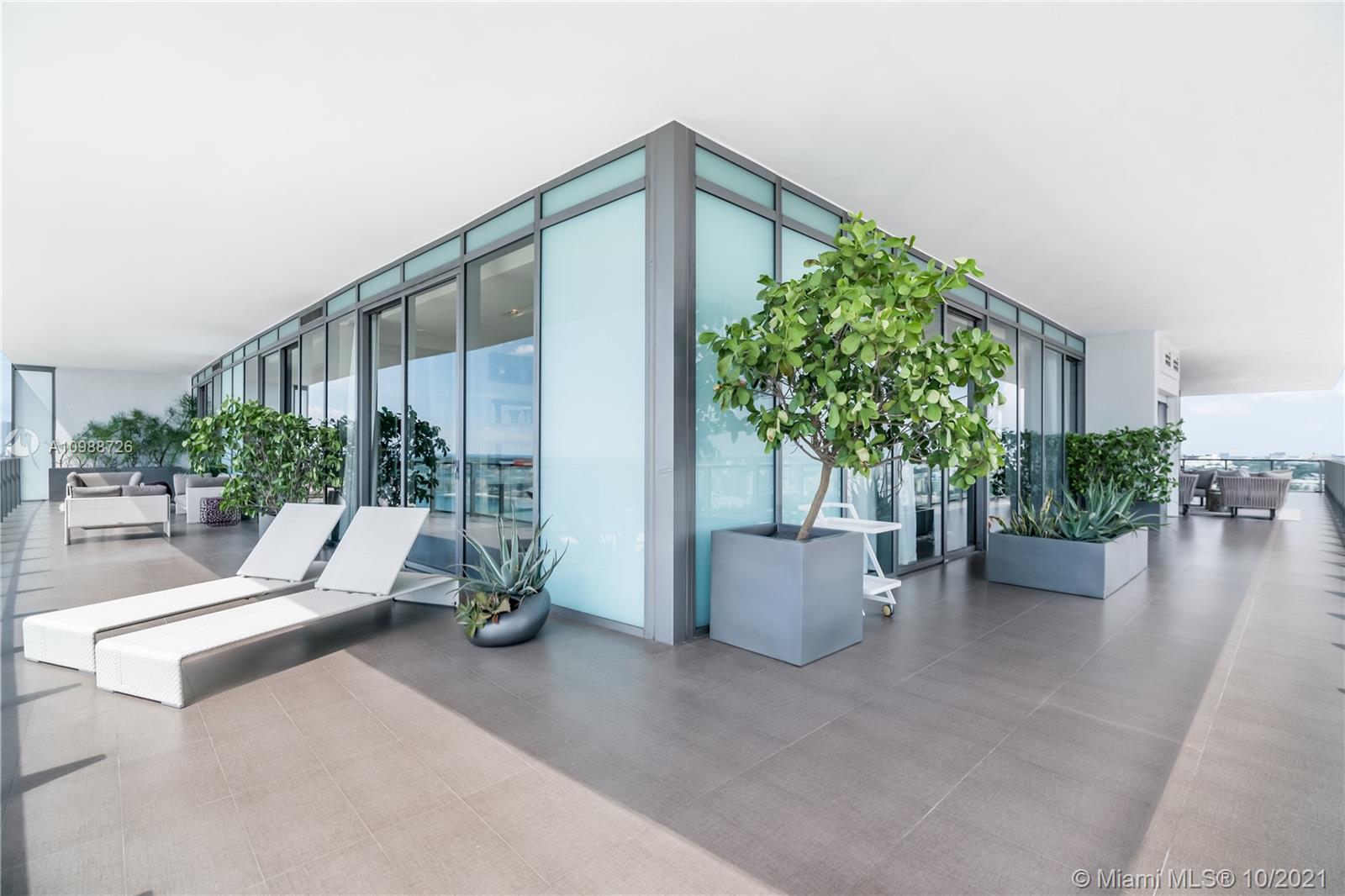 High floor Miami Beach condo balcony with ocean view and modern seating area