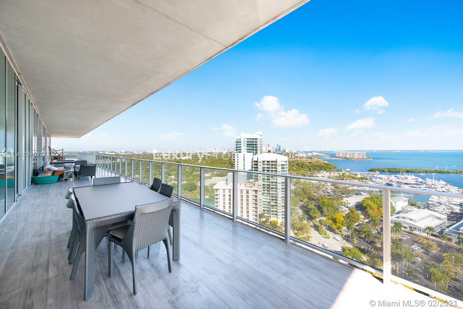 "Spacious condo balcony with stunning Miami skyline view, 6-bedroom villa for sale.",Luxury Miami condo balcony with ocean view, modern furniture, and spacious layout