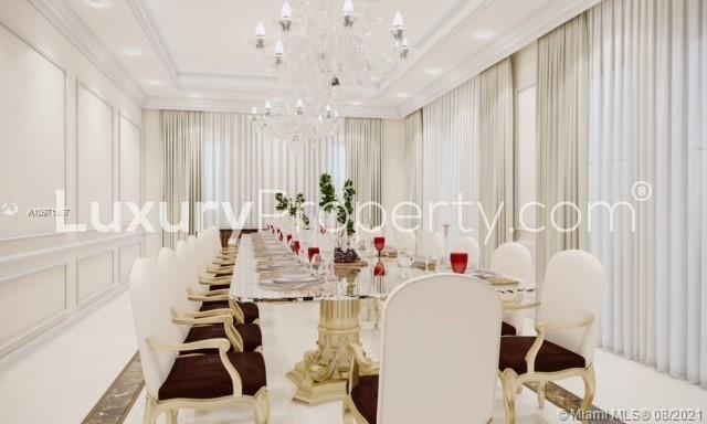 Elegant dining room in a luxury Miami villa for sale, featuring chandeliers and a long table