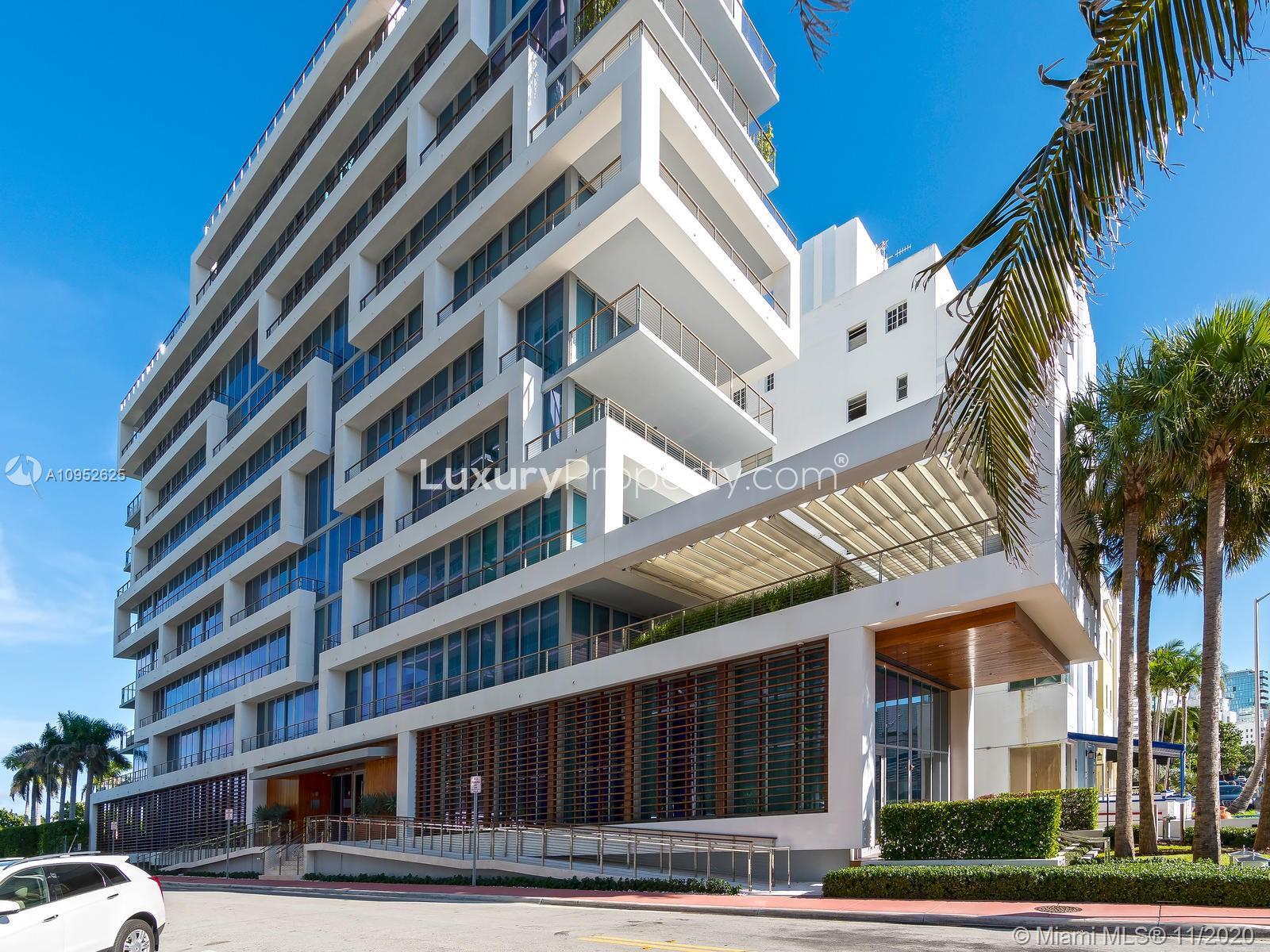 Modern Miami Beach building exterior with palm trees and clear blue sky