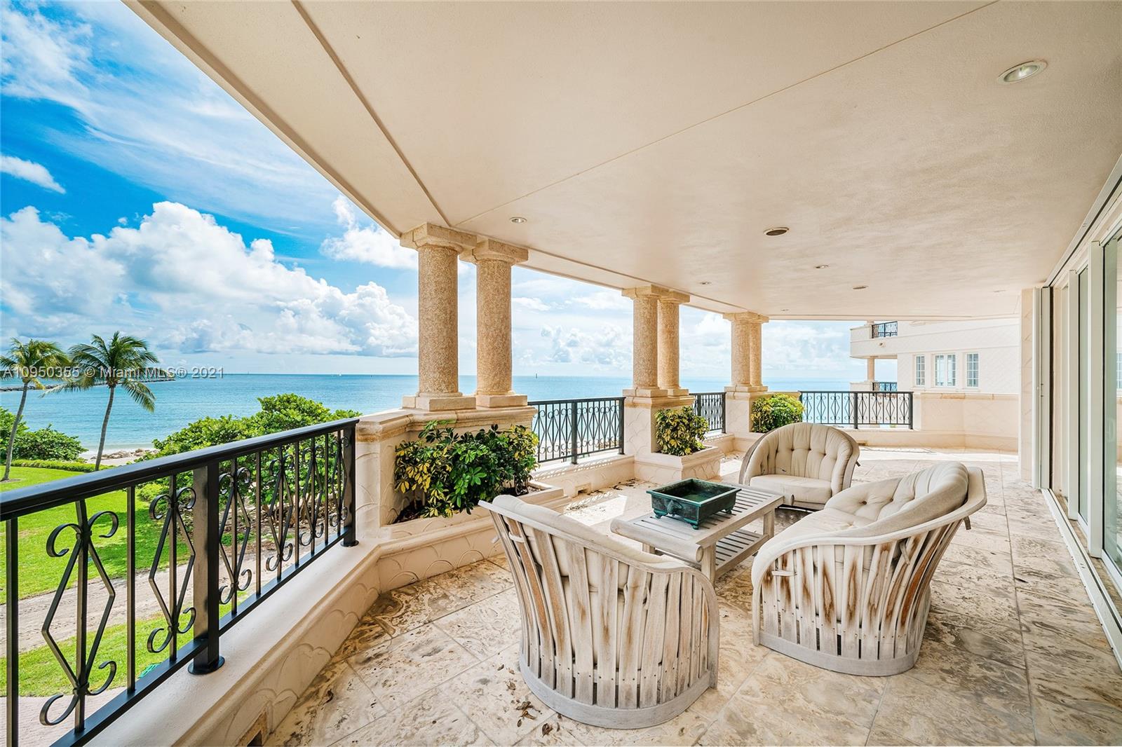 Ocean view villa terrace with seating, palm trees, and ocean in Miami, Florida