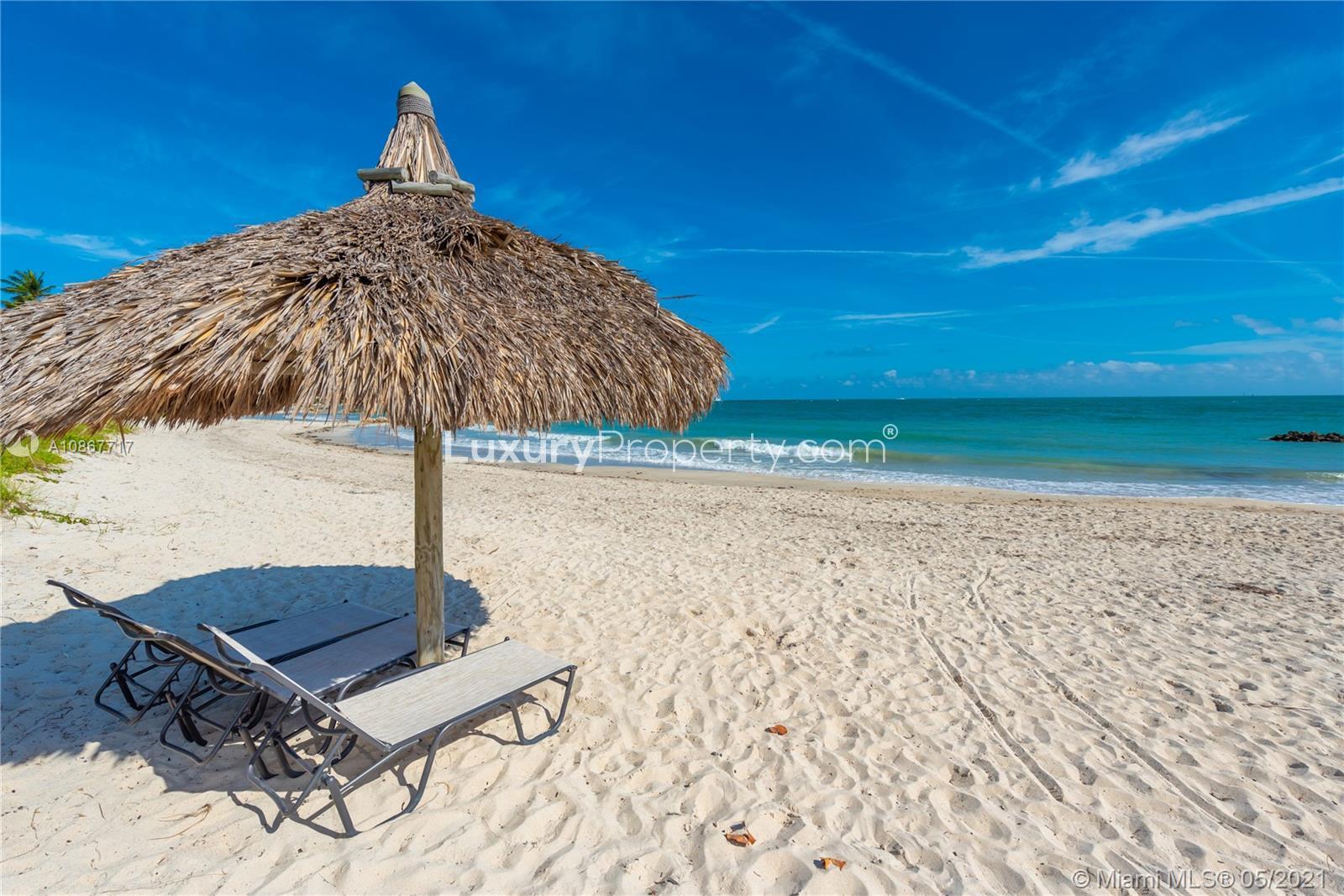 Aerial view of luxury Miami Beach villa, golf course, and water feature, Florida community