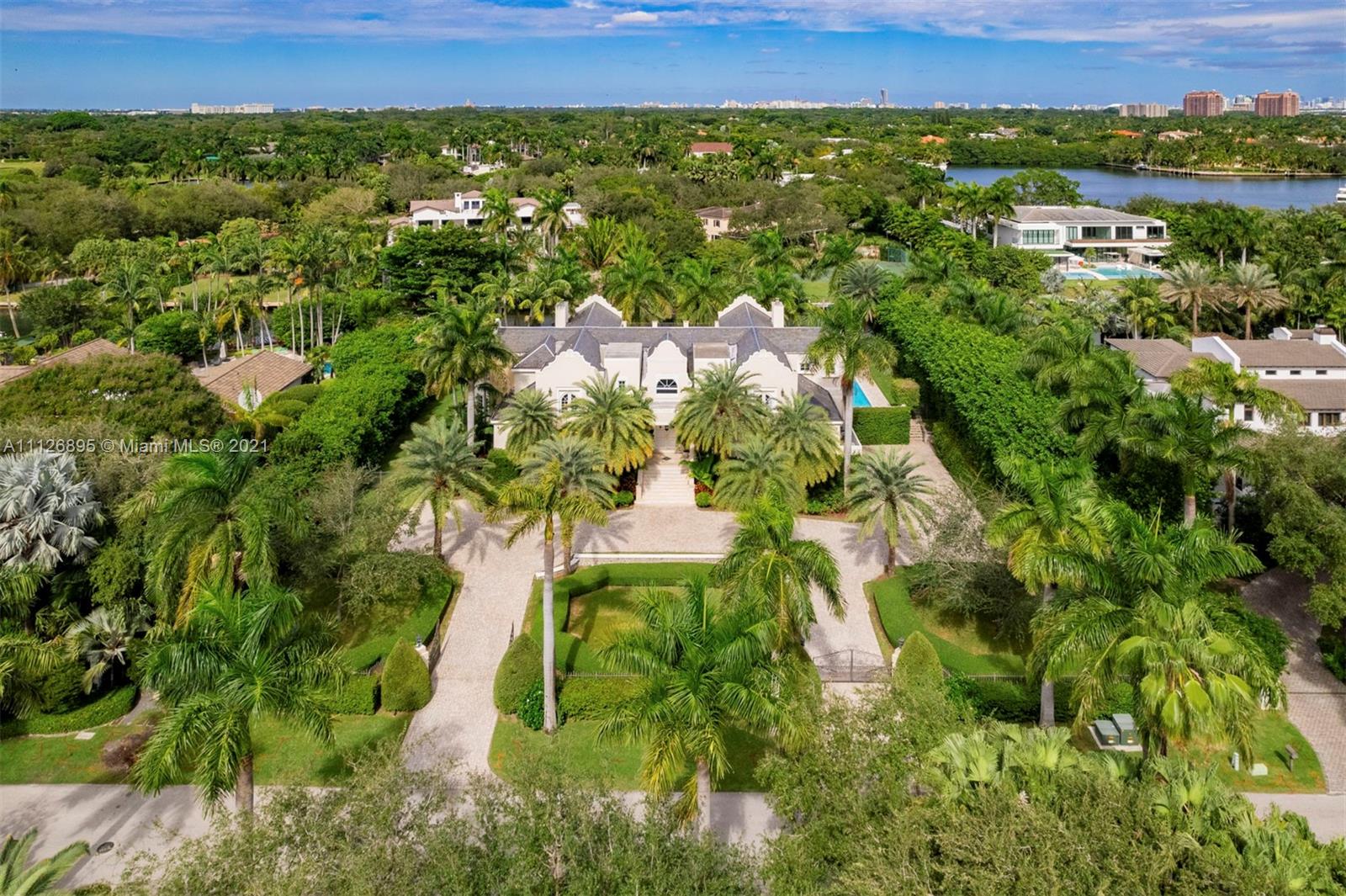 Aerial view of waterfront villa with pool at 585 Arvida Pkwy, Miami, for sale