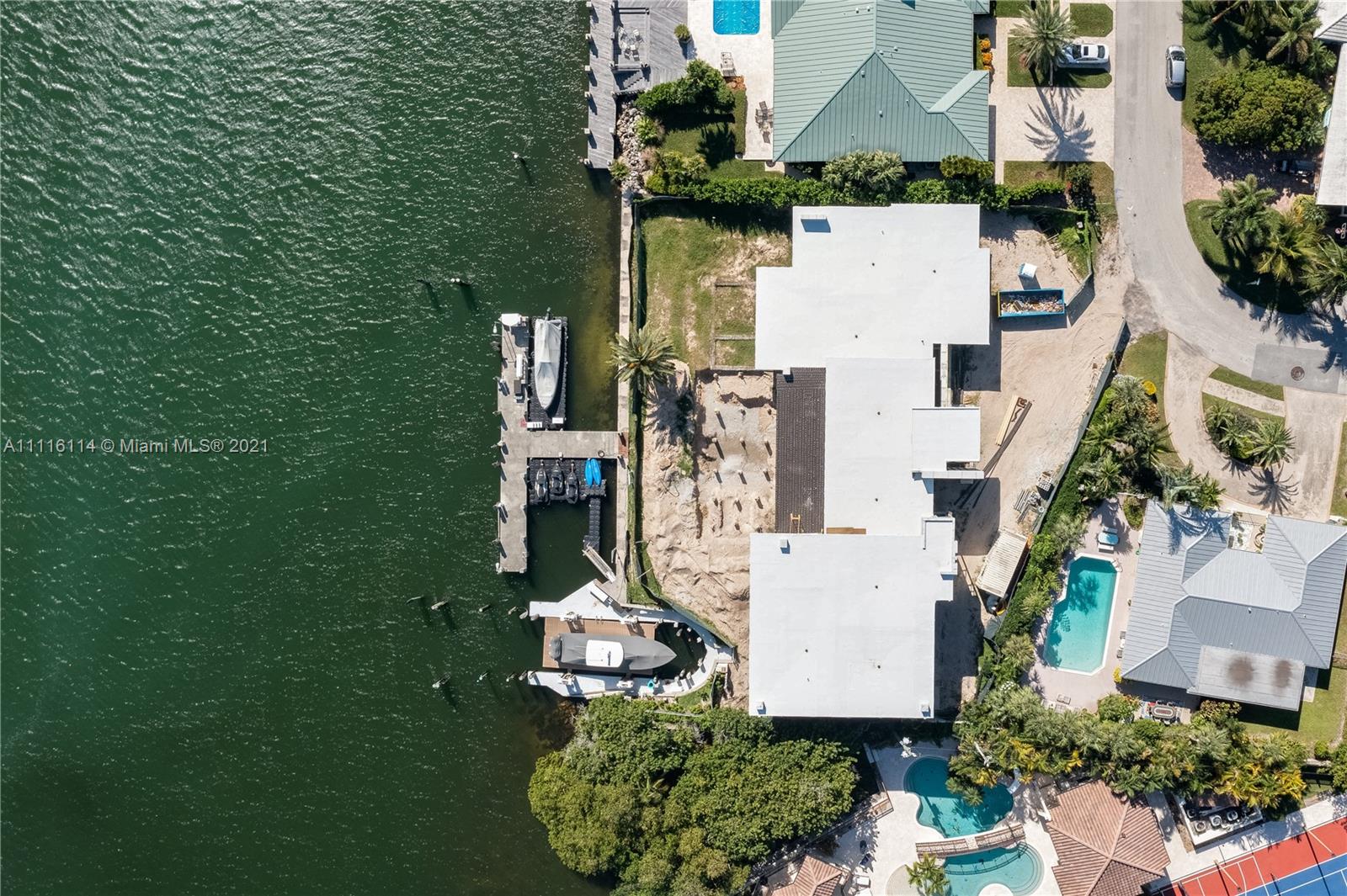 Waterfront villa with modern design, dock, and palm trees in Miami, Florida