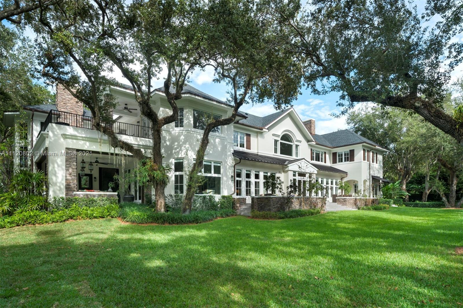 Villa for sale in Miami, Florida: elegant facade, spacious driveway, lush greenery