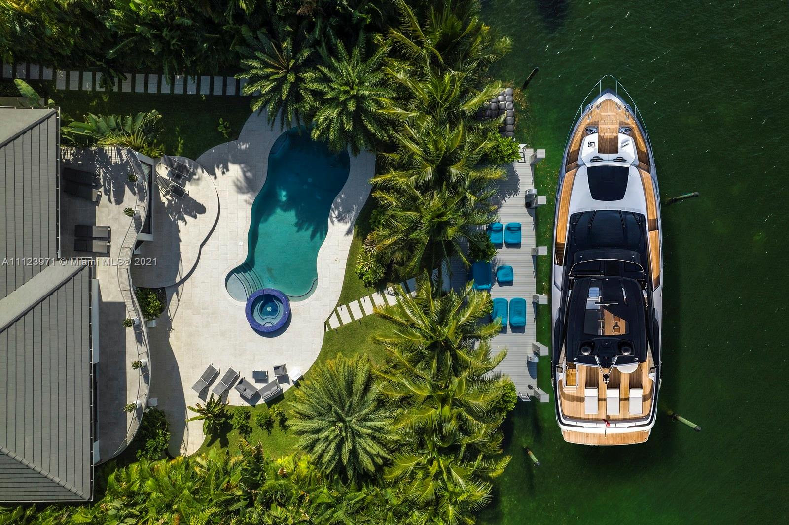Aerial view of waterfront villa with pool and yacht at 1380 Biscaya Dr, Miami