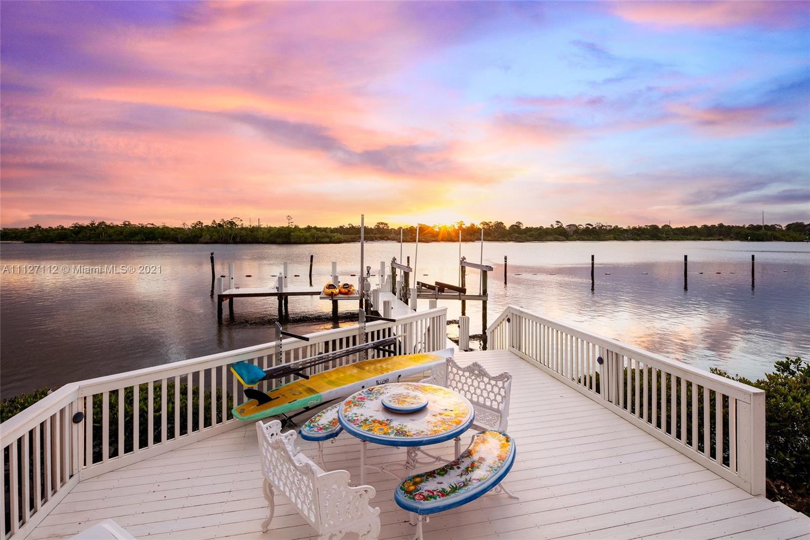 Dock view of luxury villa at sunset, 372 Regatta Dr, Jupiter, Florida