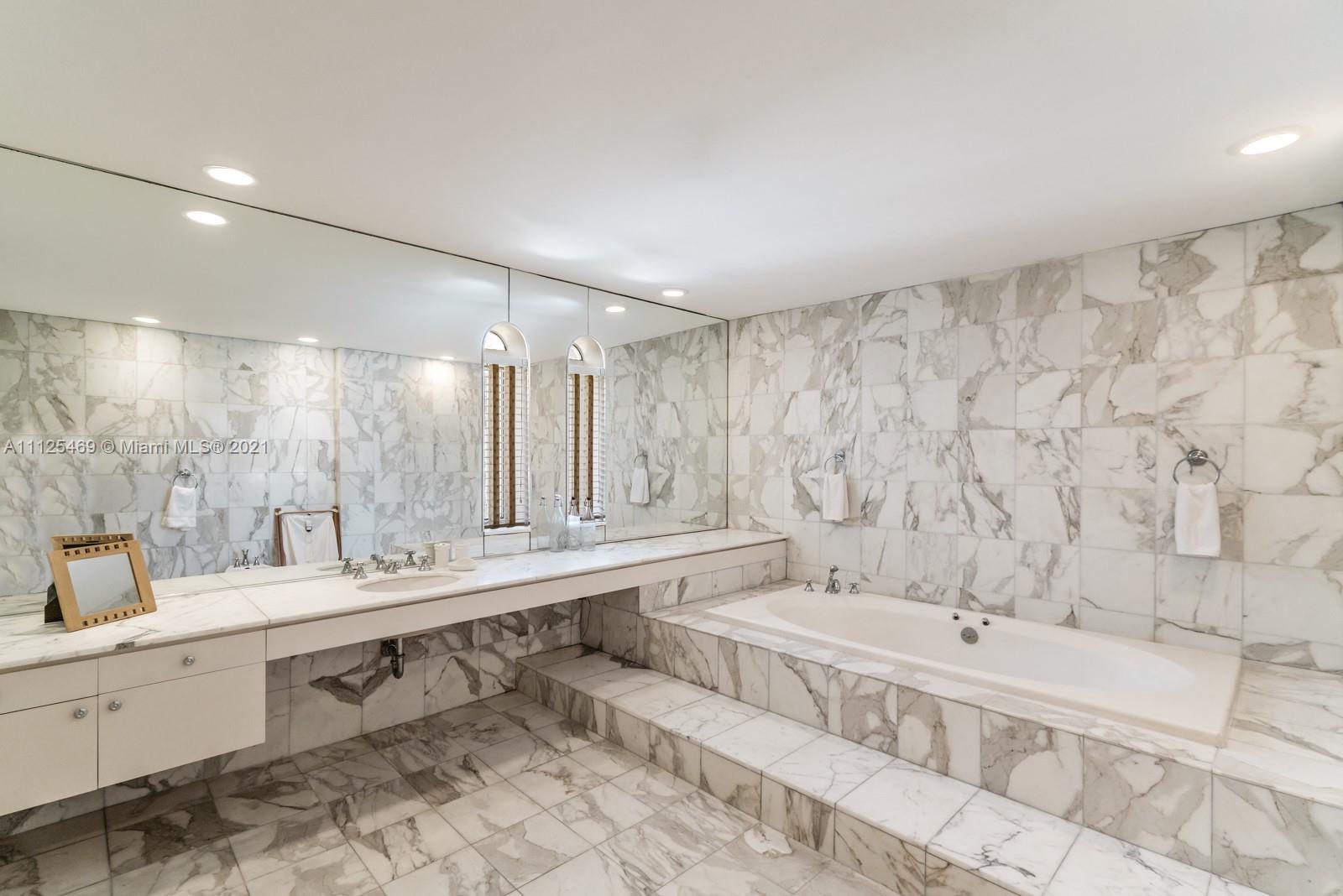 "Spacious bedroom in furnished waterfront villa, Miami, with ample storage and hardwood floors.",Luxurious marble bathroom in 9-bed waterfront villa, 3029 Brickell Avenue, Miami, Florida