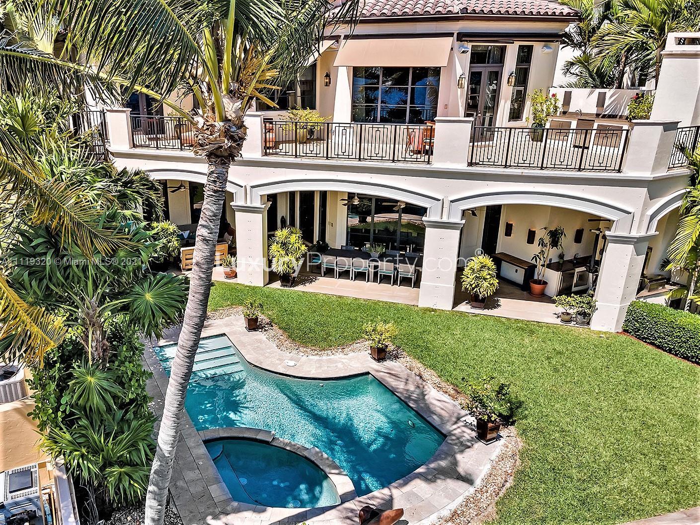 Aerial view of waterfront mansion at 4036 Island Estates Dr, Aventura, with pool and palm trees