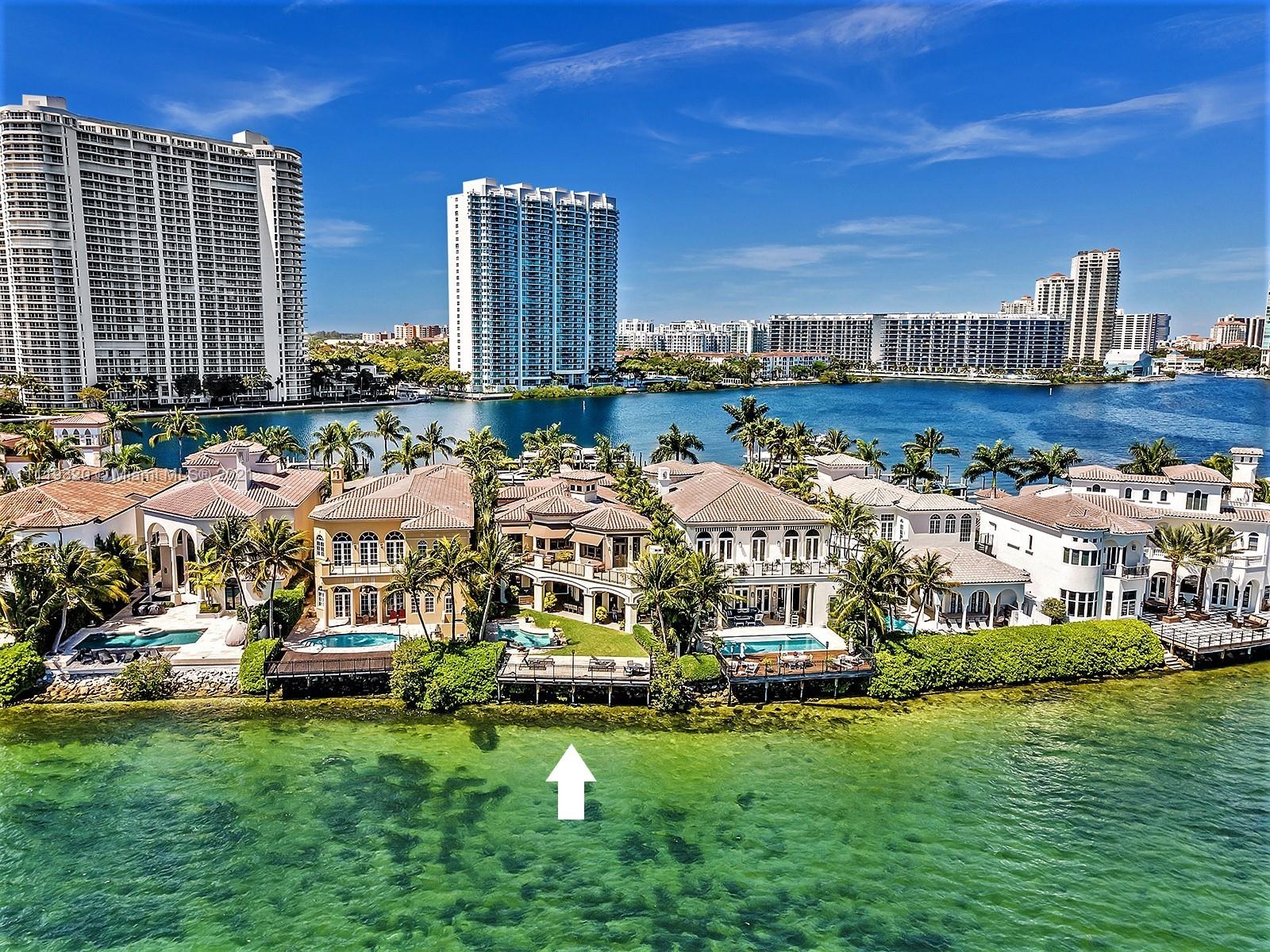 Aerial view of luxury waterfront mansion with boat slip in Aventura, Florida