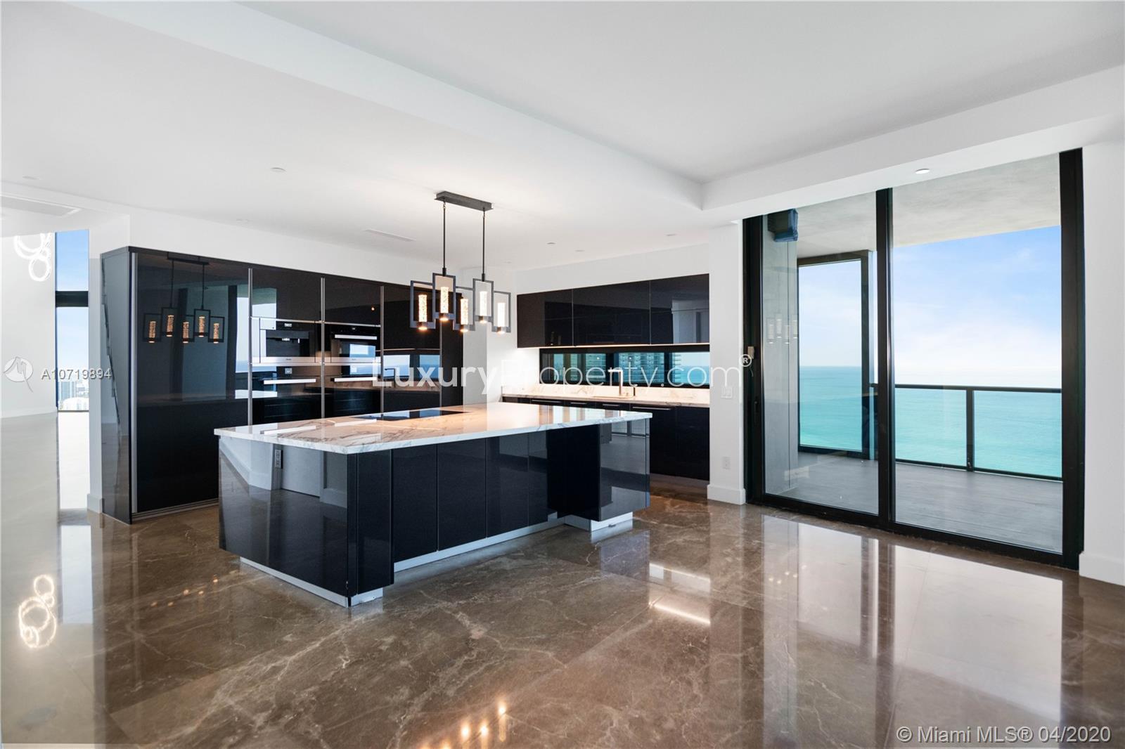 Modern kitchen with sleek black cabinetry in Miami duplex villa for sale