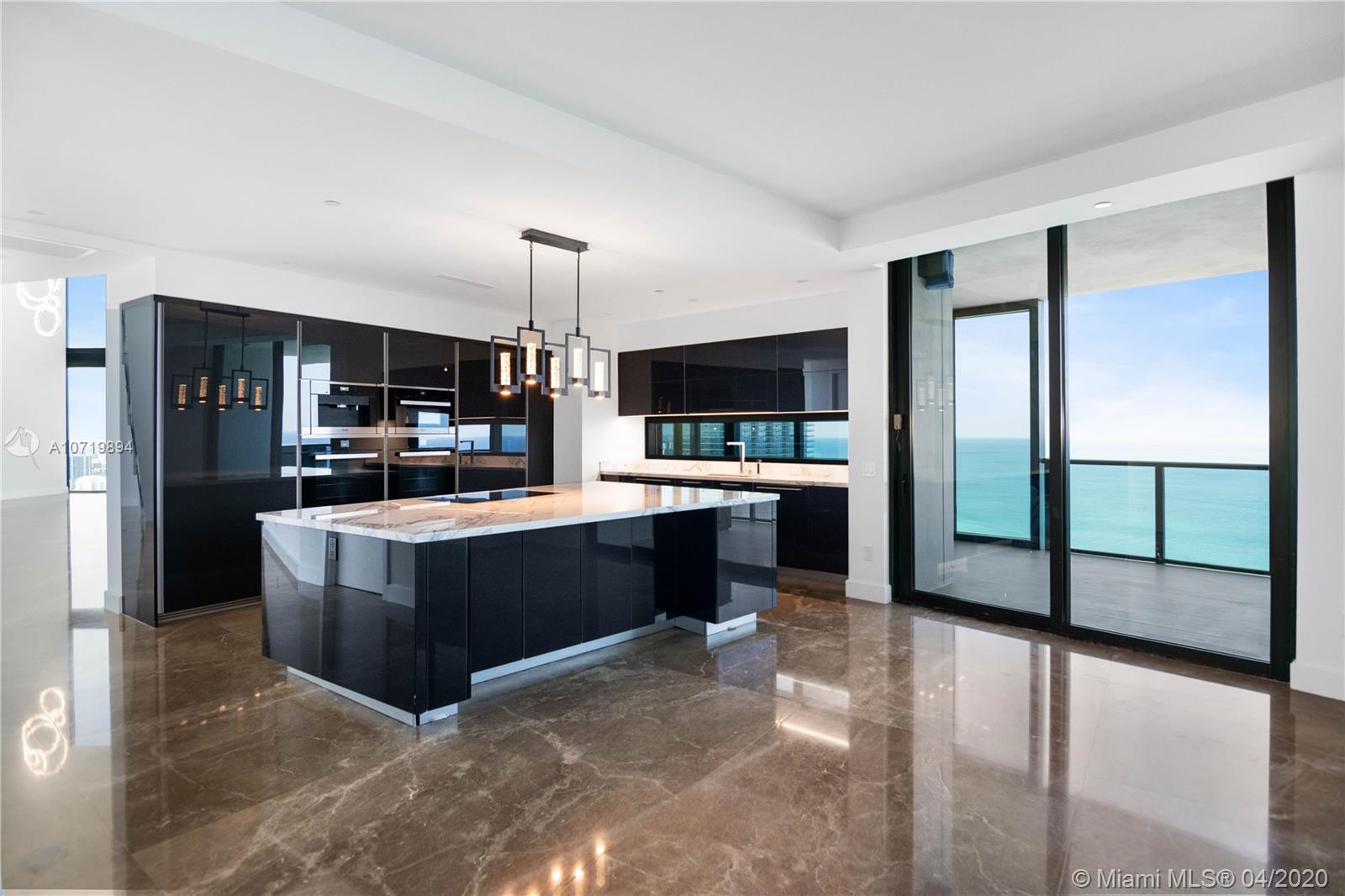 Modern kitchen with sleek black cabinetry in Miami duplex villa for sale