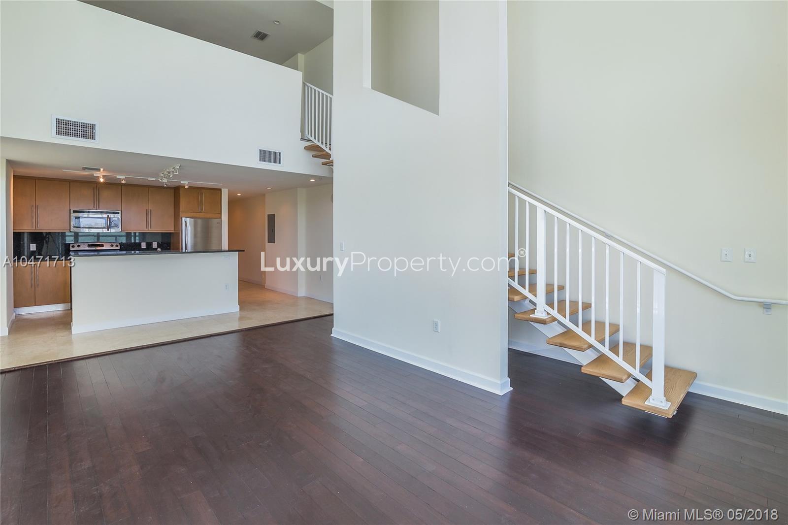 Spacious open-plan kitchen and living area in Miami waterfront condo villa for sale