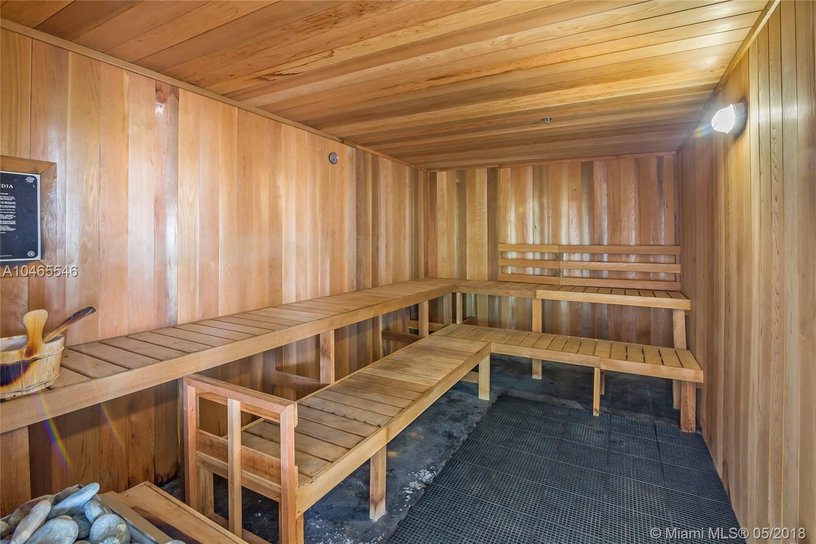 "Modern gym in waterfront condo, North Bay Village, Miami, with ocean view and equipment.","Luxurious sauna in modern waterfront condo, North Bay Village, Miami villa for sale.",Modern condo lobby in North Bay Village, Miami with large windows and elegant seating area