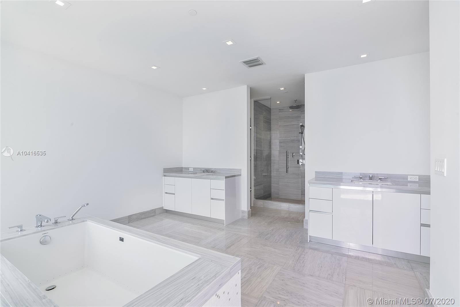 "Stunning Downtown Miami view from luxury penthouse balcony at 16901 Collins Avenue, 5303.",Luxurious bathroom in Miami penthouse villa with modern fixtures, spacious tub, and sleek design