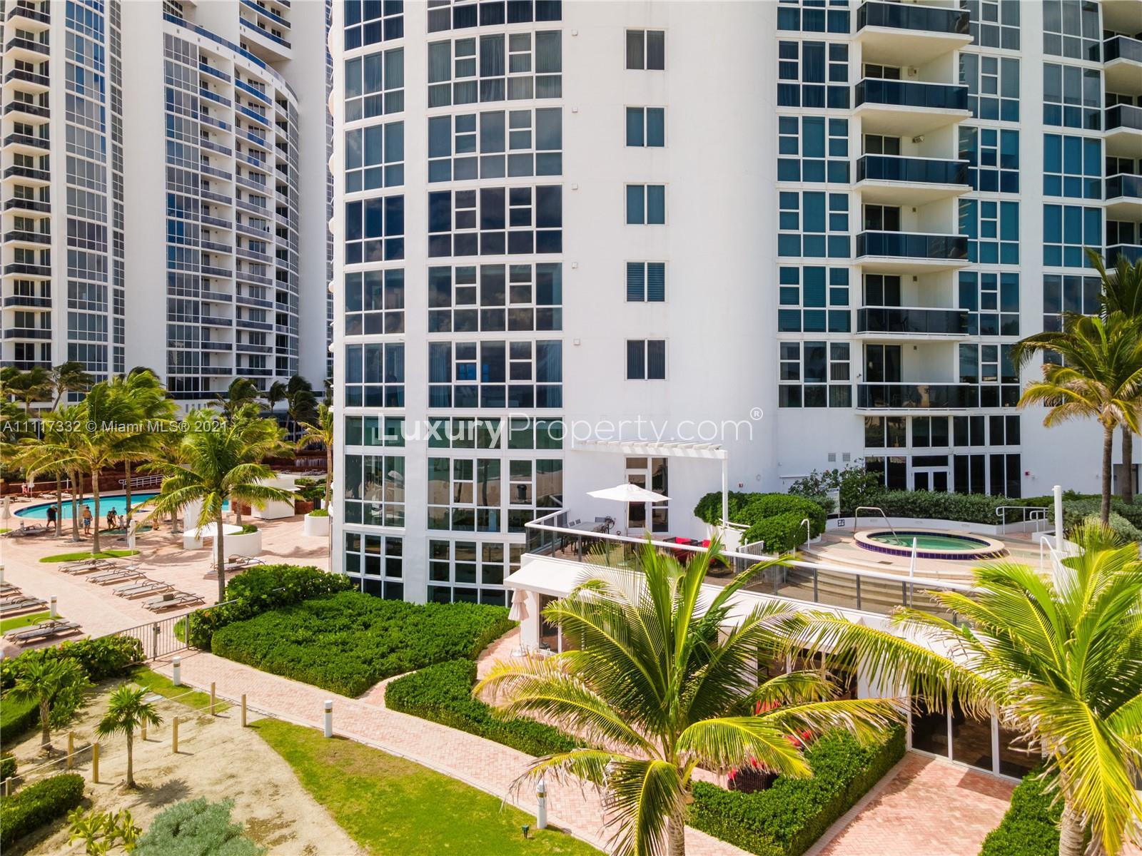 Oceanview furnished beach villa exterior with palm trees at 18201 Collins Ave, Miami